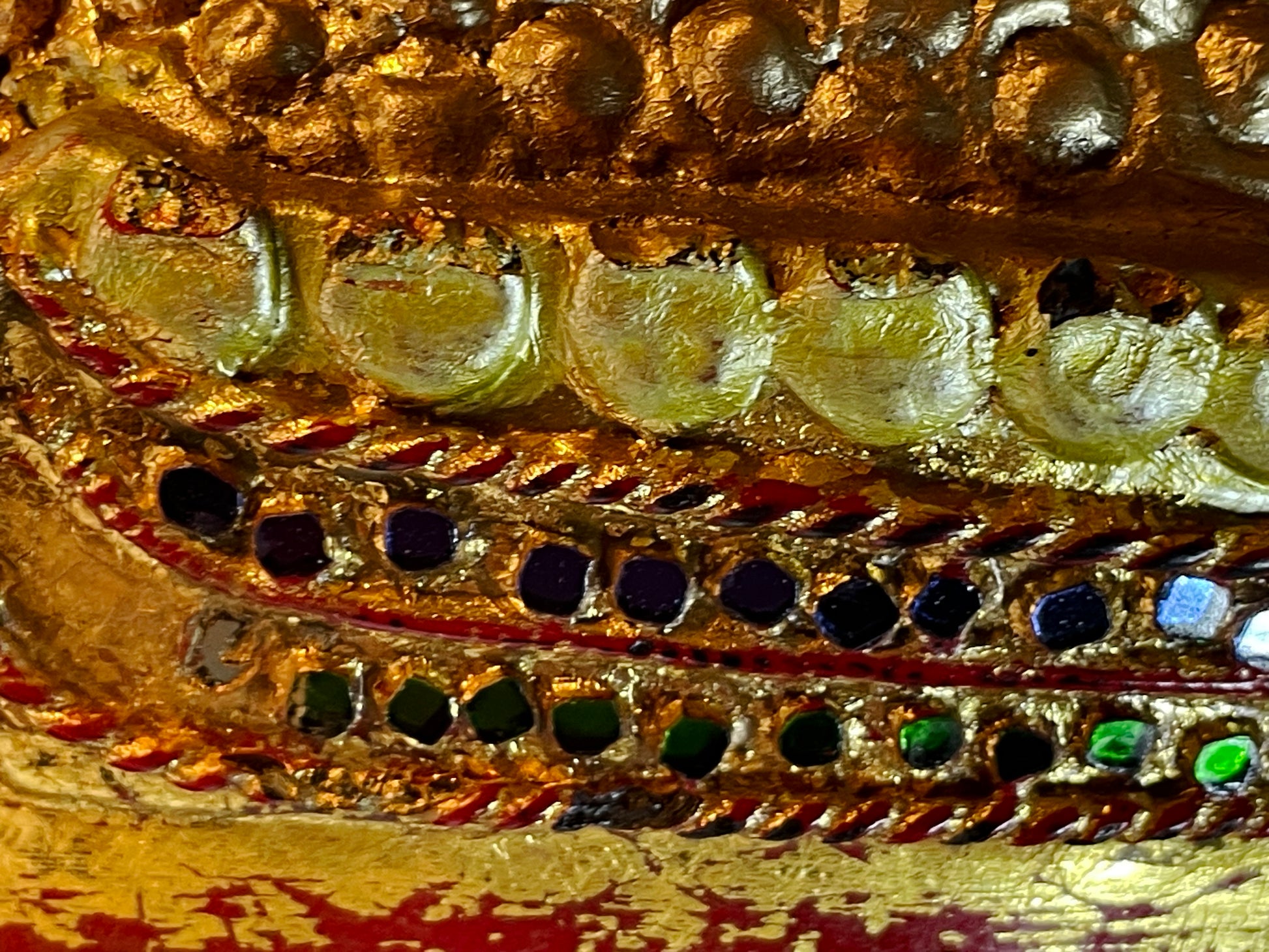 Close-up of the jewelled headband inlaid with coloured glass and the beaded ushnisha