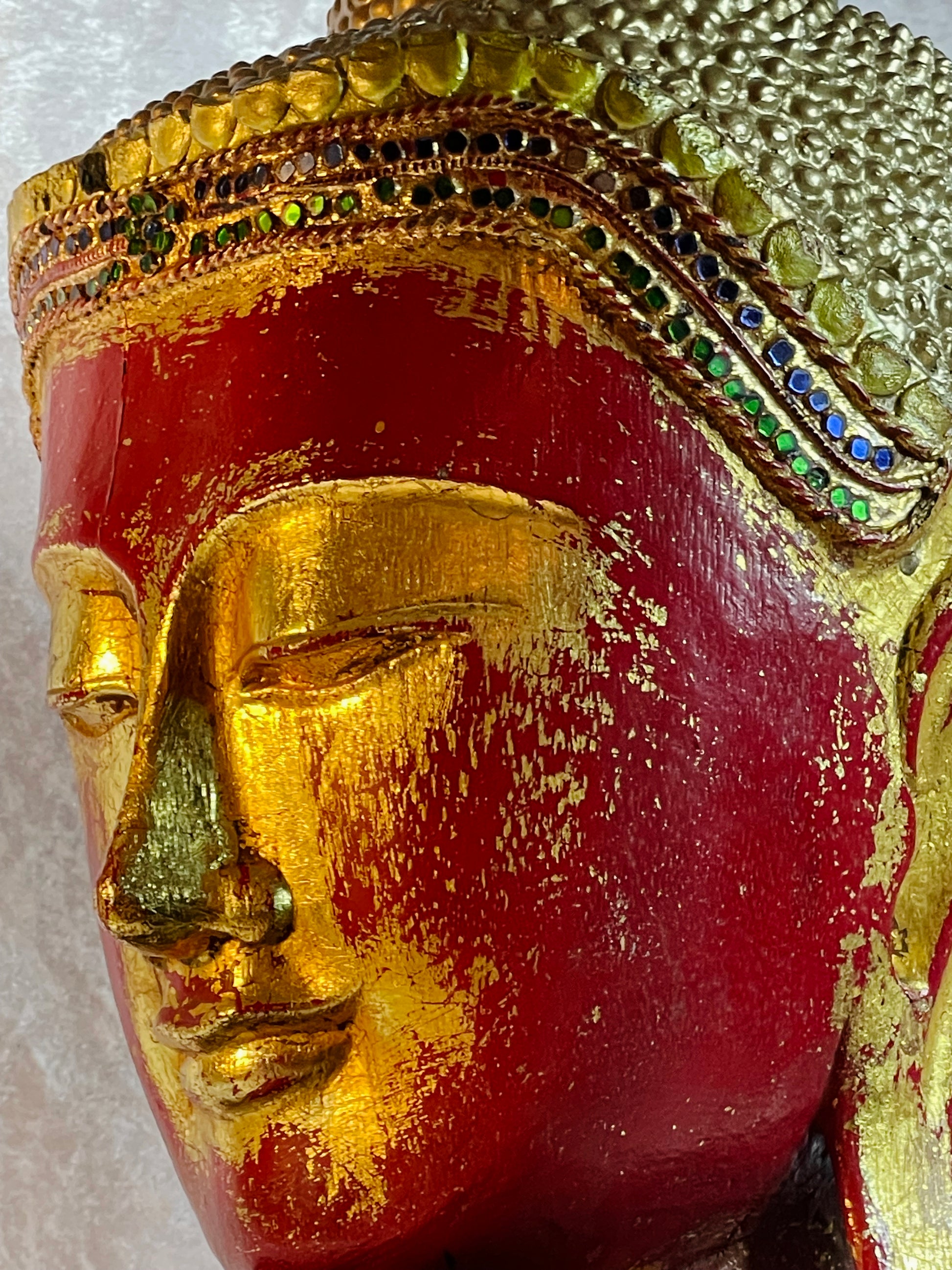 Three-quarter close-up of the Buddha's serene gilded face and jewelled diadem