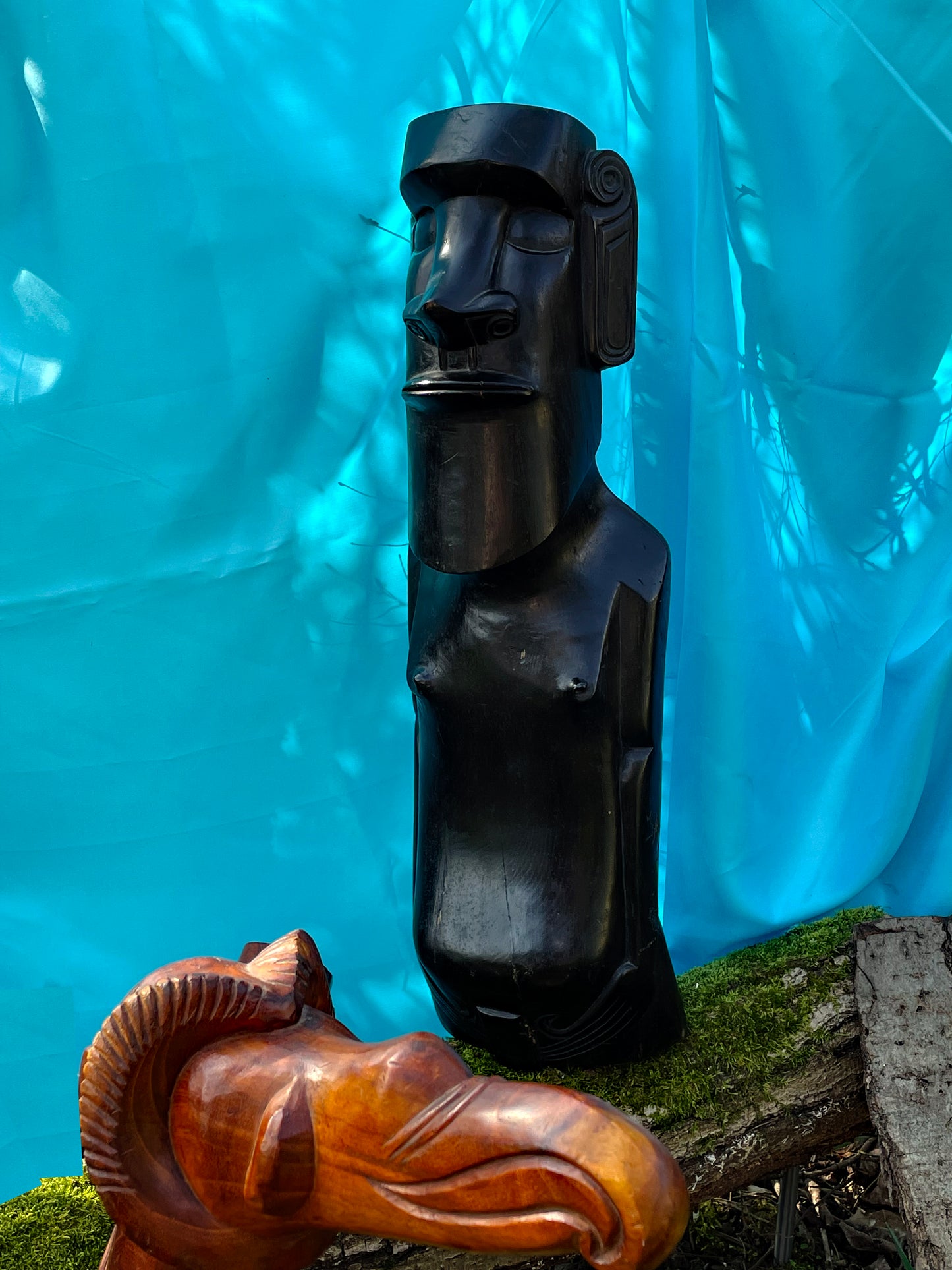 Close-up of the black Moai face showing carved features and patina