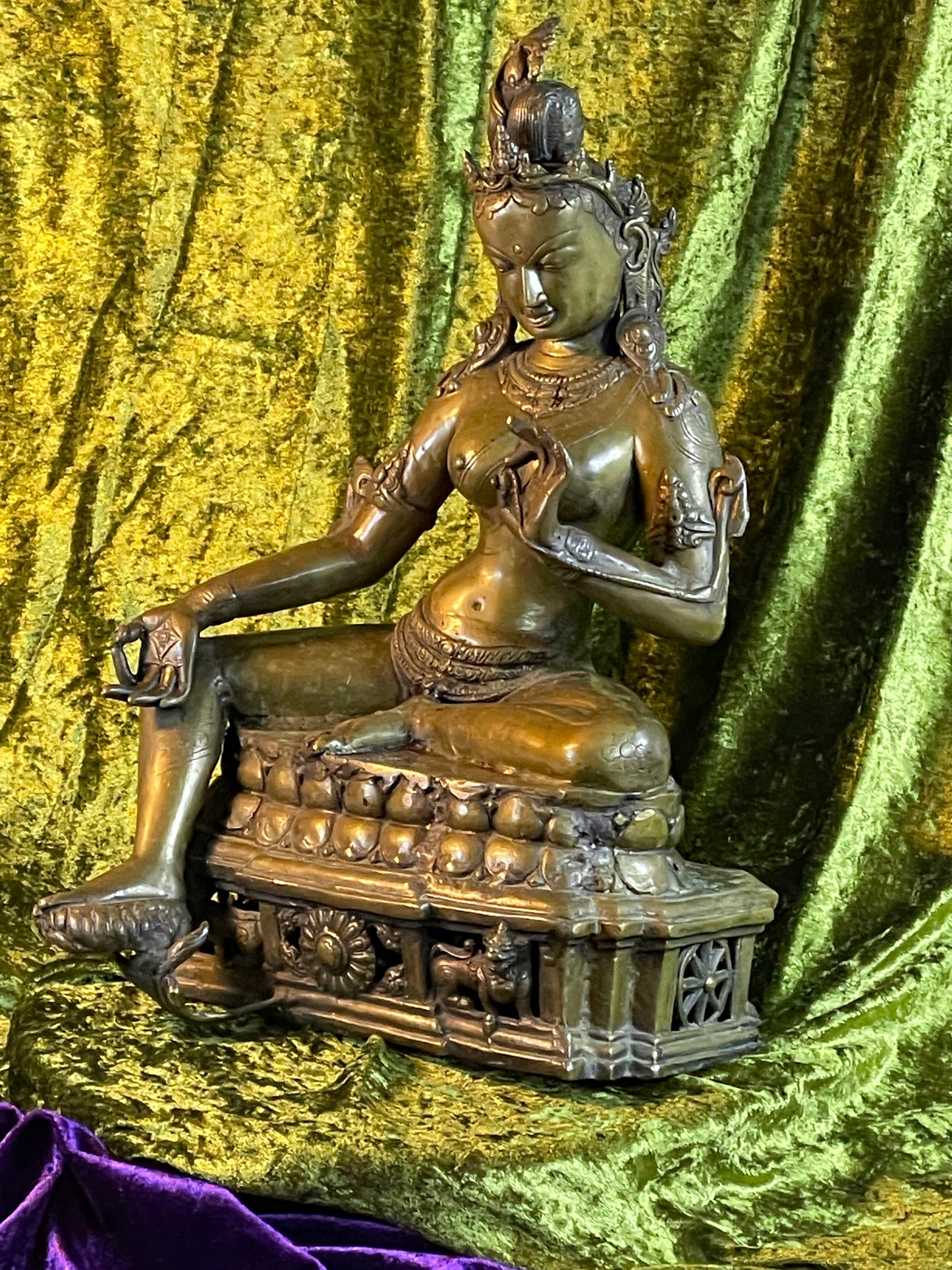 Angled view of the Tibetan Green Tara bronze on its double lotus throne