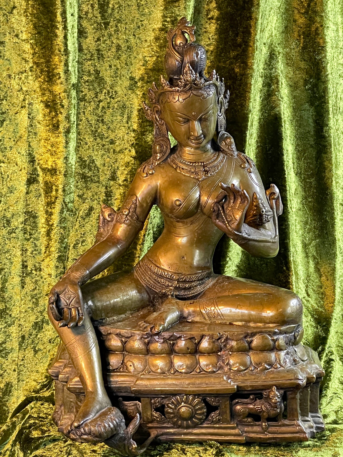 Front view of the bronze Green Tara figure showing crown, jewellery and lotus base