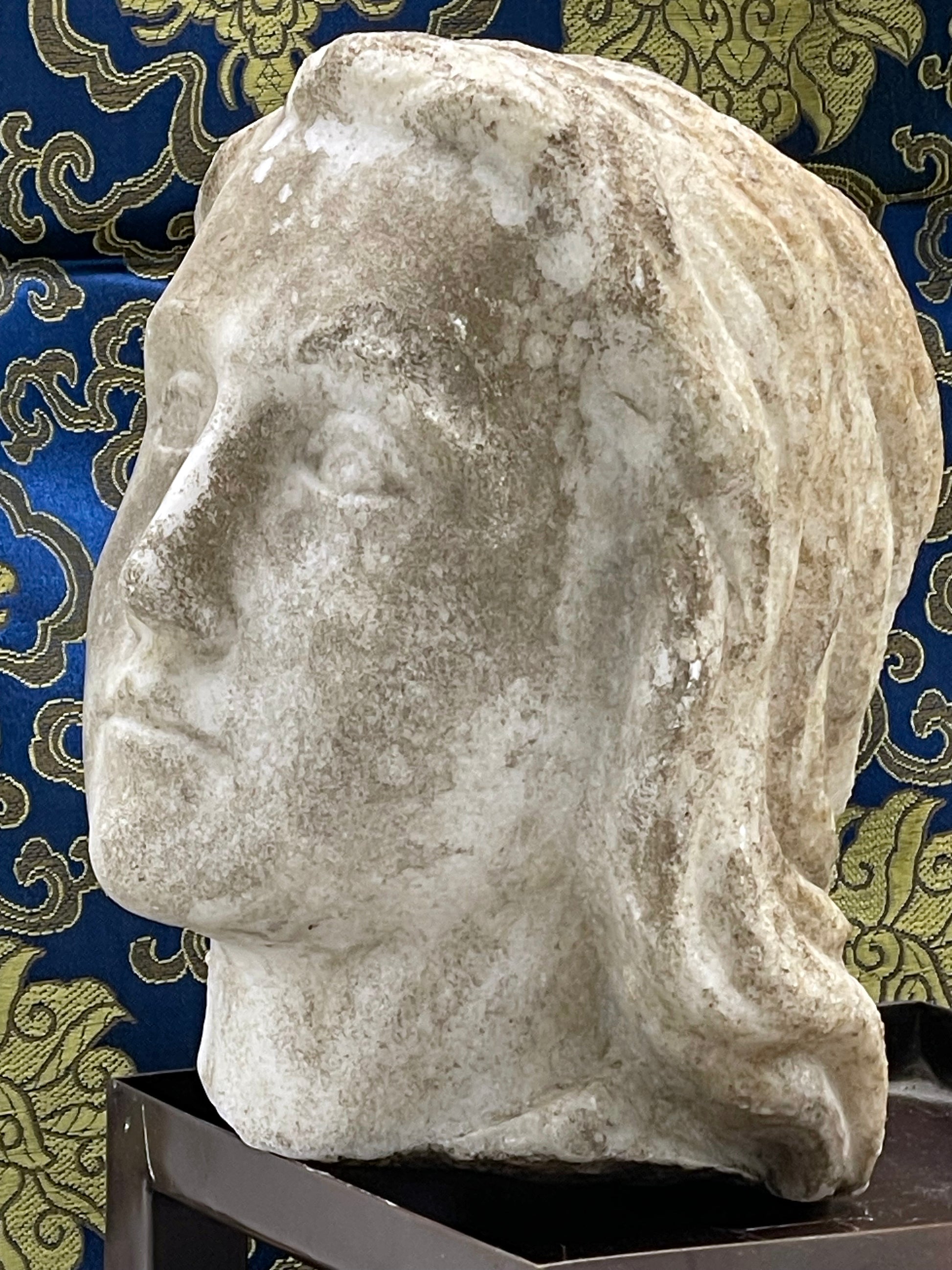 Carved marble flowing hair detail with patina