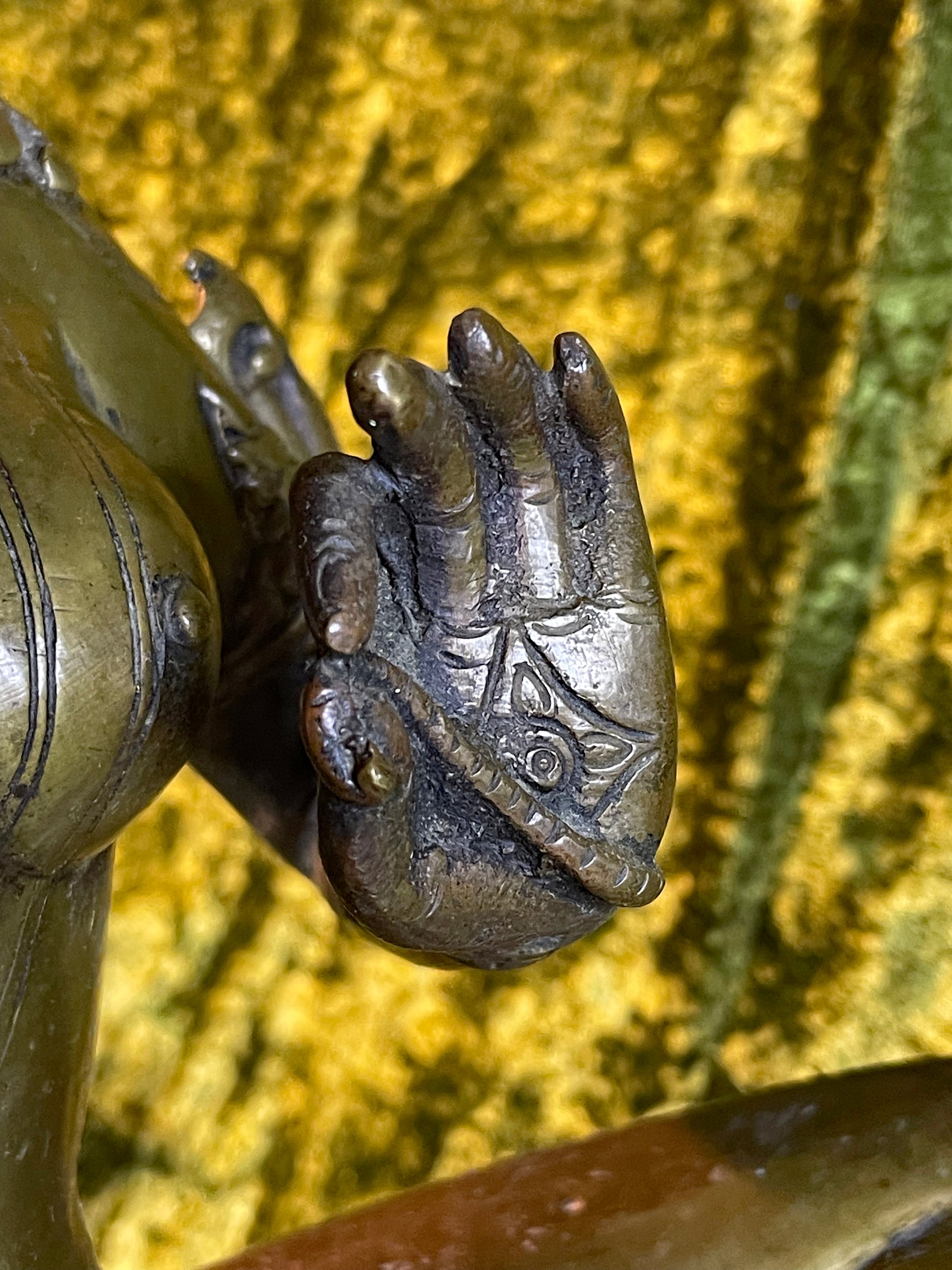 Close up of Green Tara's hand in varada mudra
