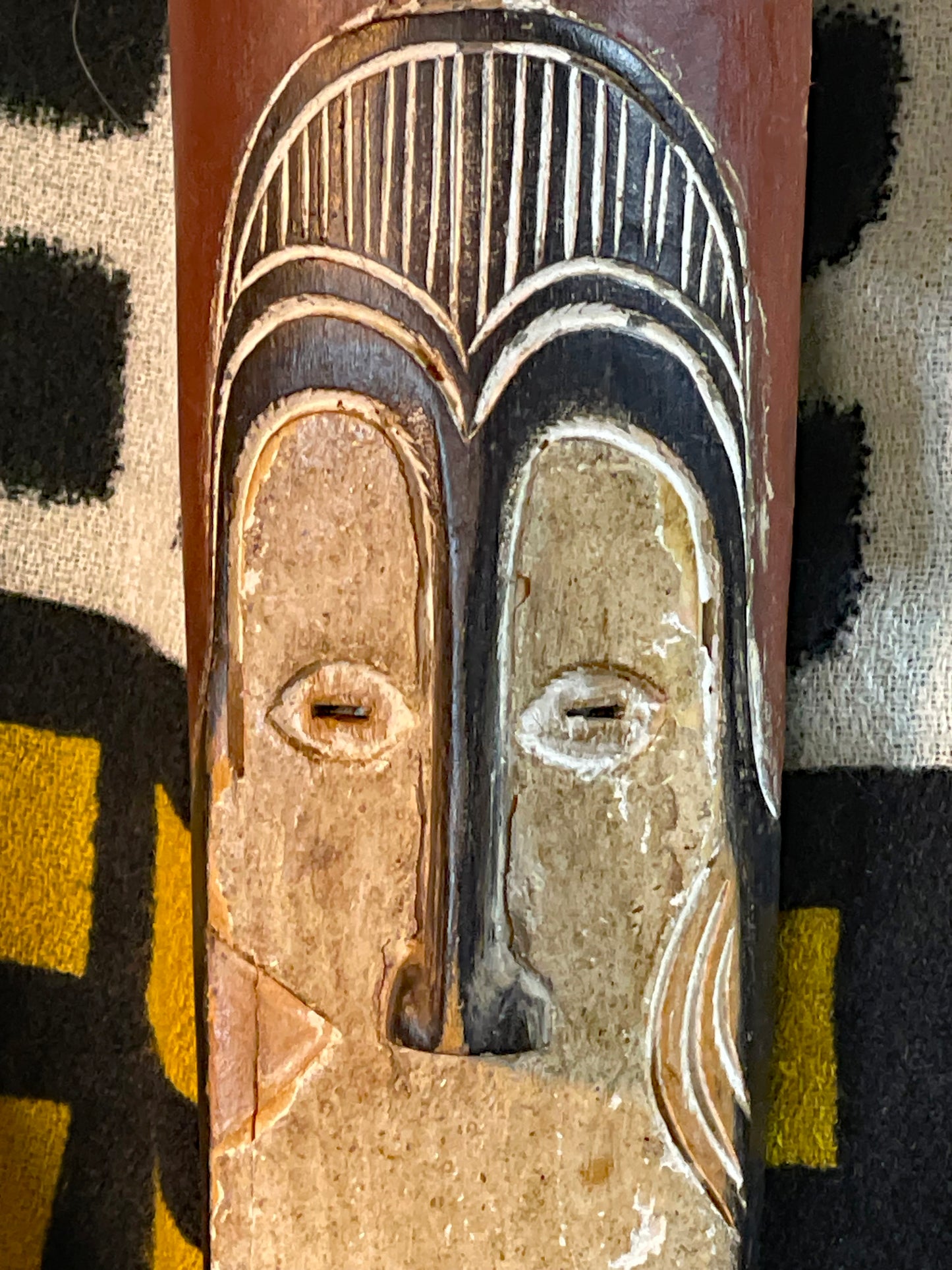 Close-up of the whitened heart-shaped face and carved eyes of the African mask