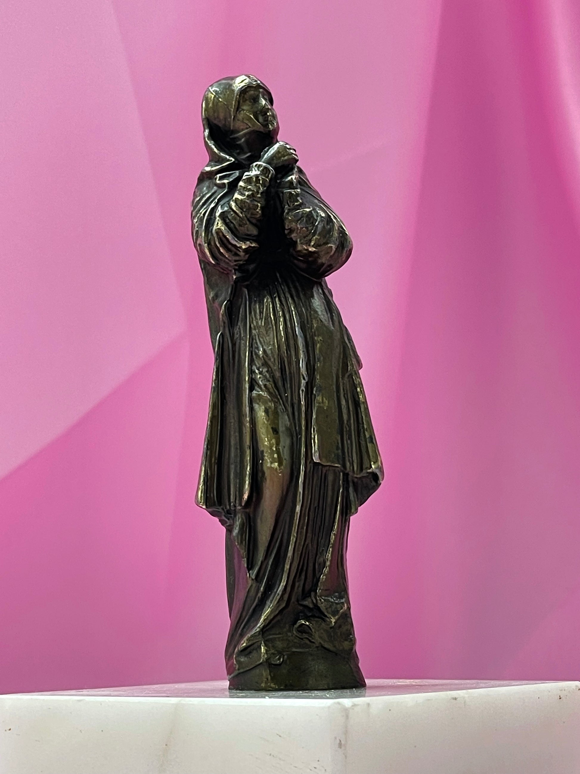 Close view of patinated bronze praying Maria figure