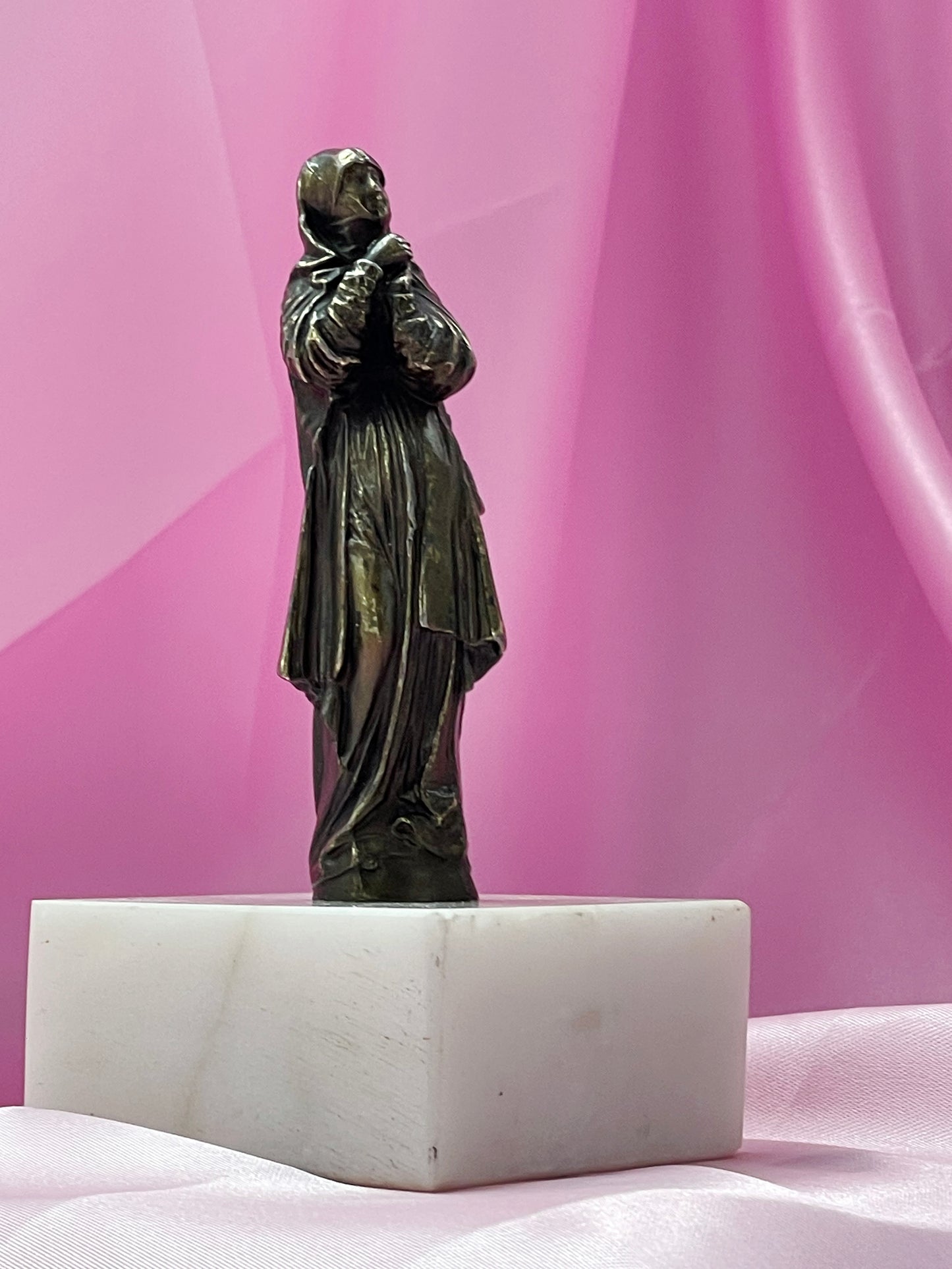 Devotional bronze saint figure showing flowing robes and veil
