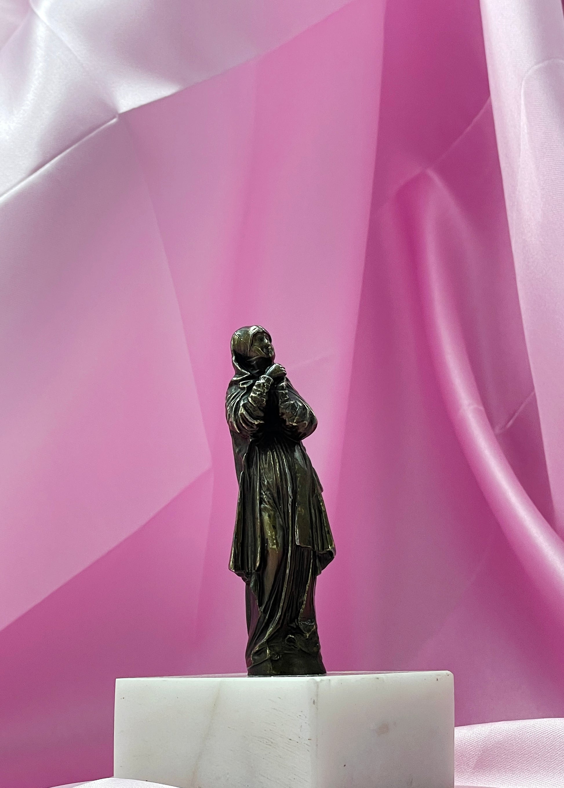 Bronze Madonna figure with hands clasped in prayer, side view