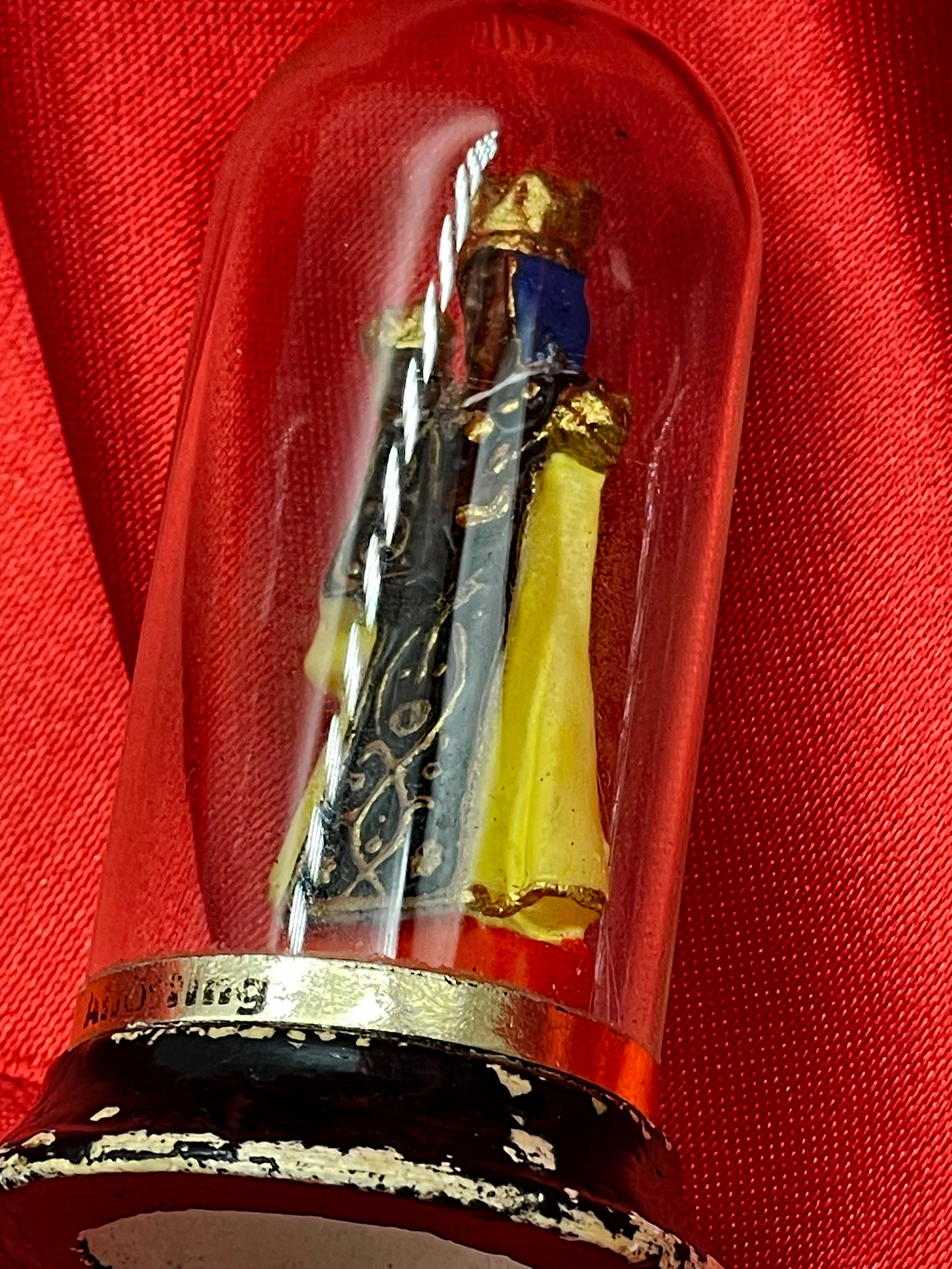 Side view of Black Madonna figure under glass dome