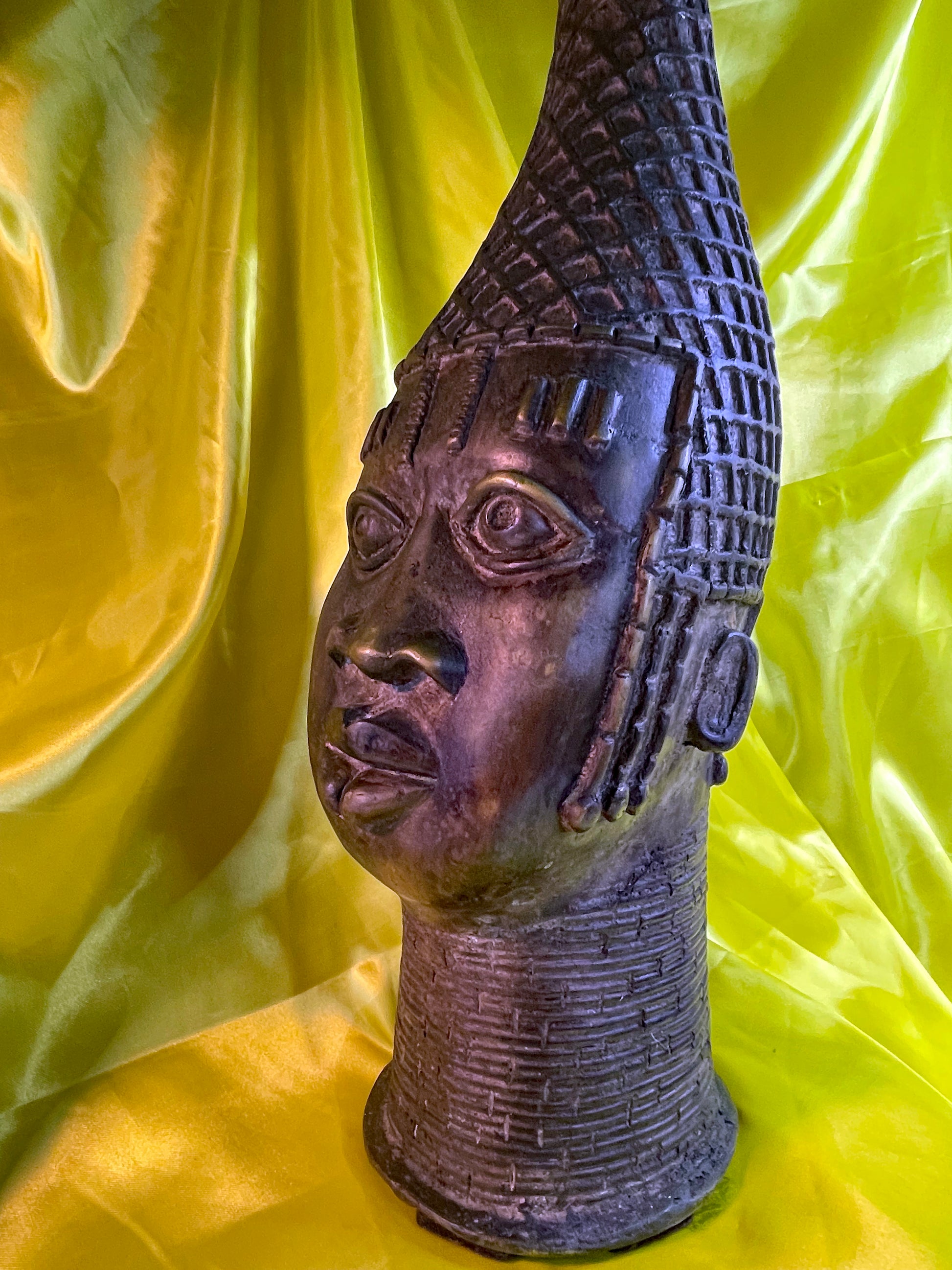 Three quarter view of the Benin bronze head showing face, crown and beaded collar