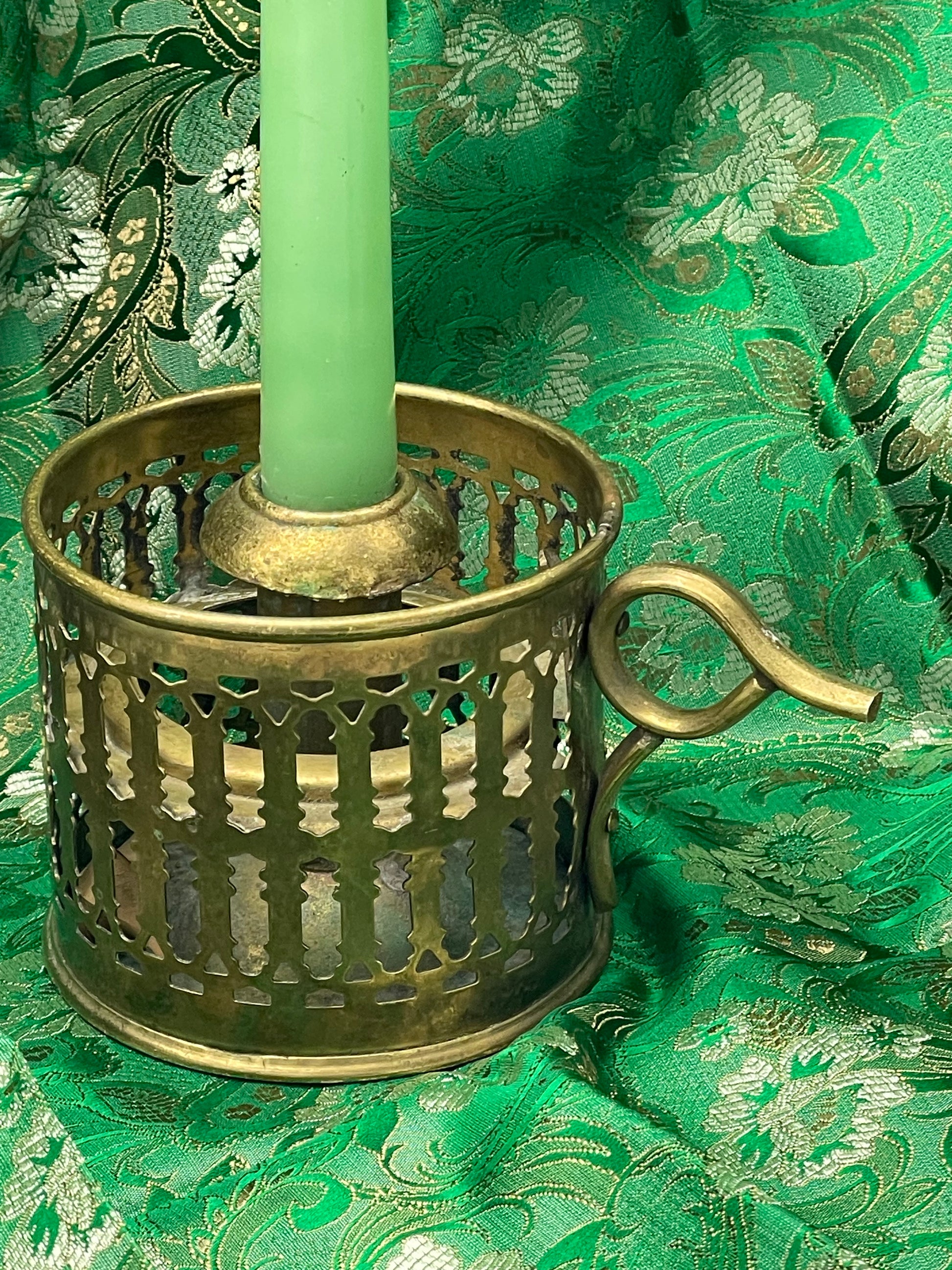 Side view of antique brass chamberstick with finger loop