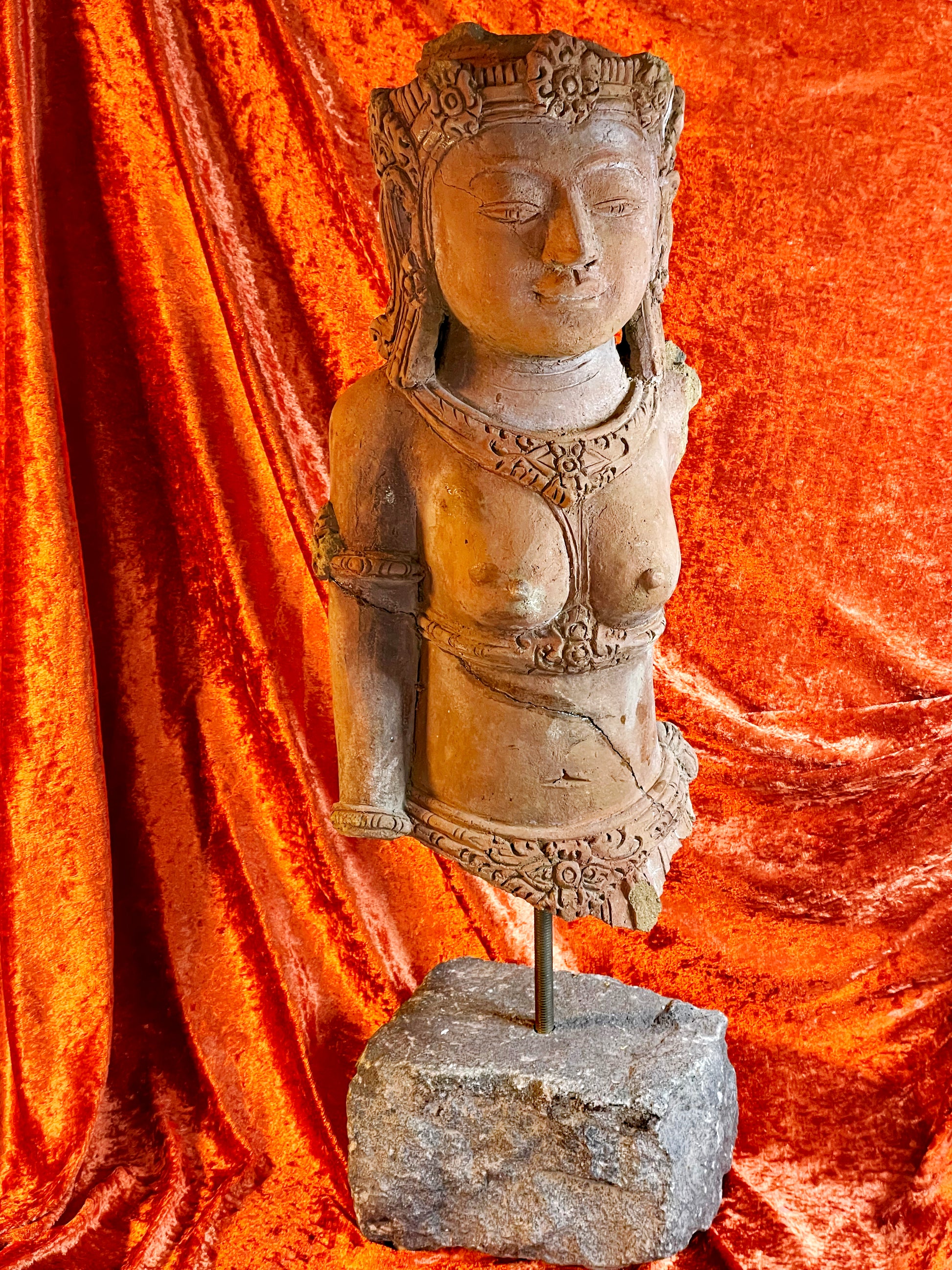 Close detail of weathered terracotta goddess sculpture