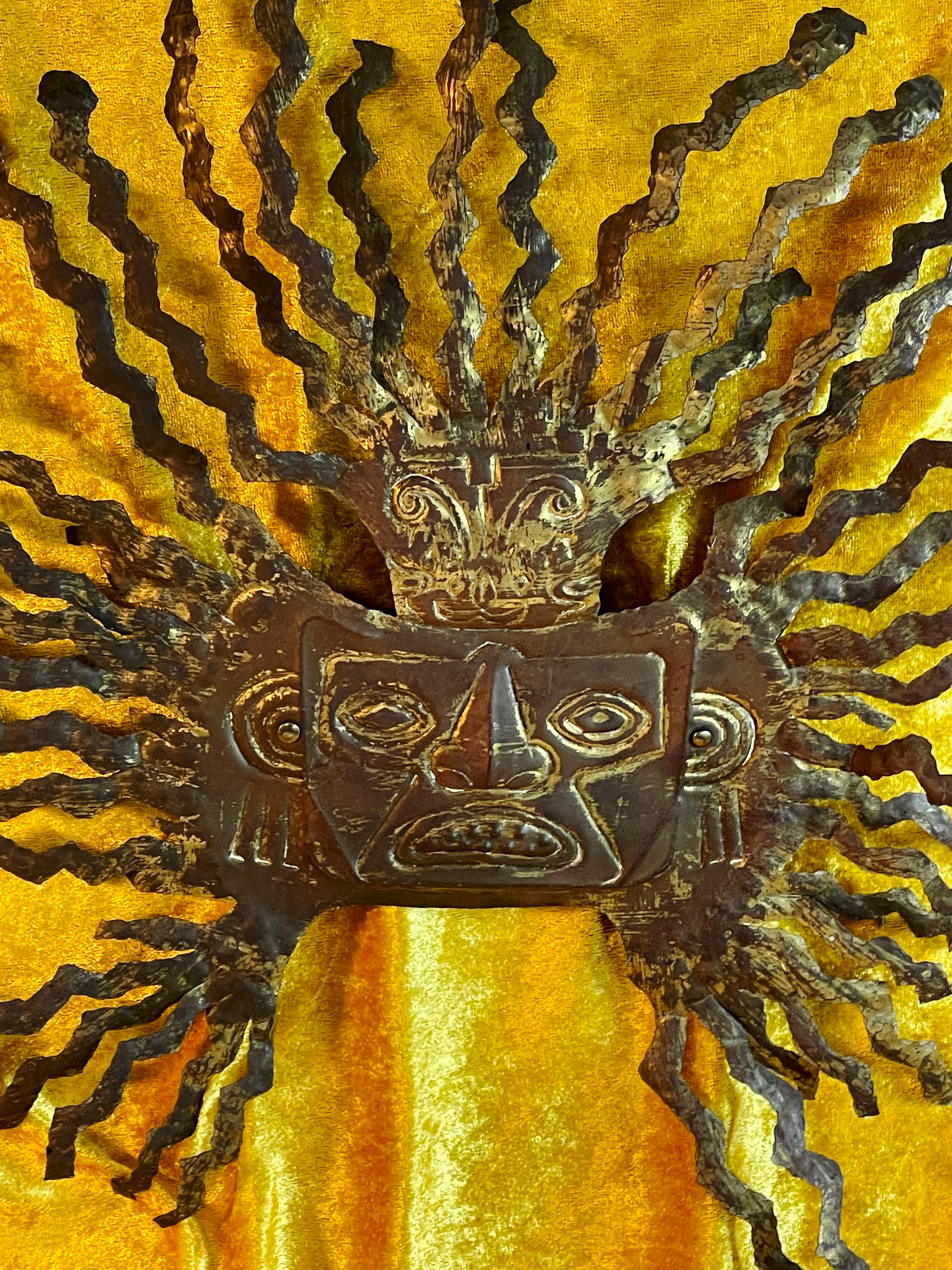 Brass sun god mask facial features close up