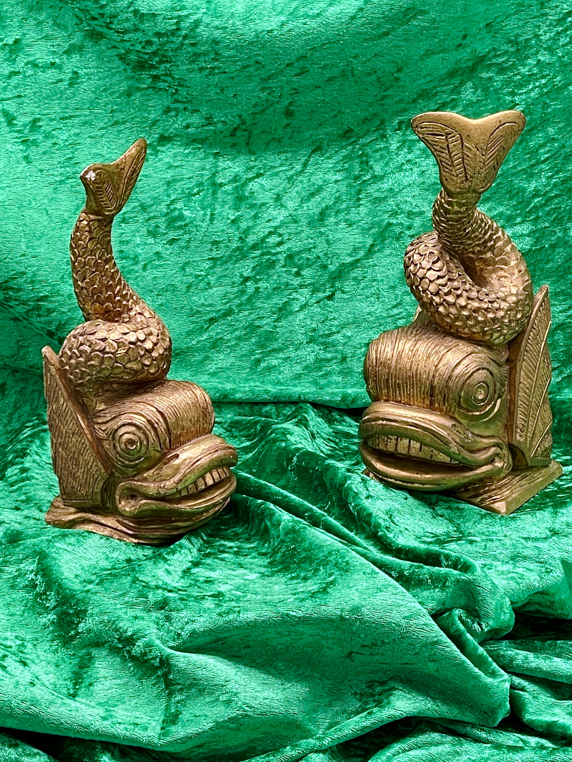 Pair of gilded carved wood fish figures on green velvet