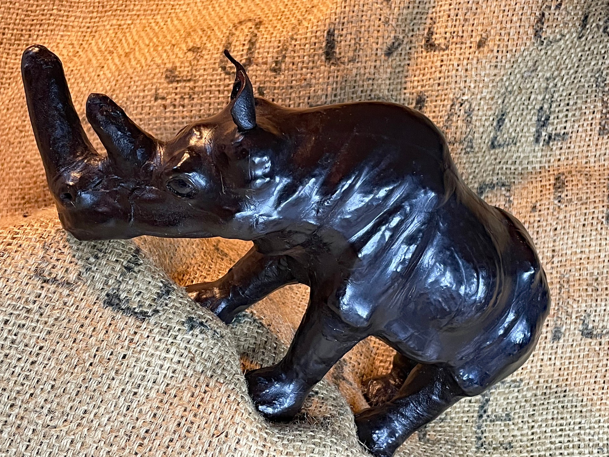 Three-quarter view of the leather rhino showing the double horn and form