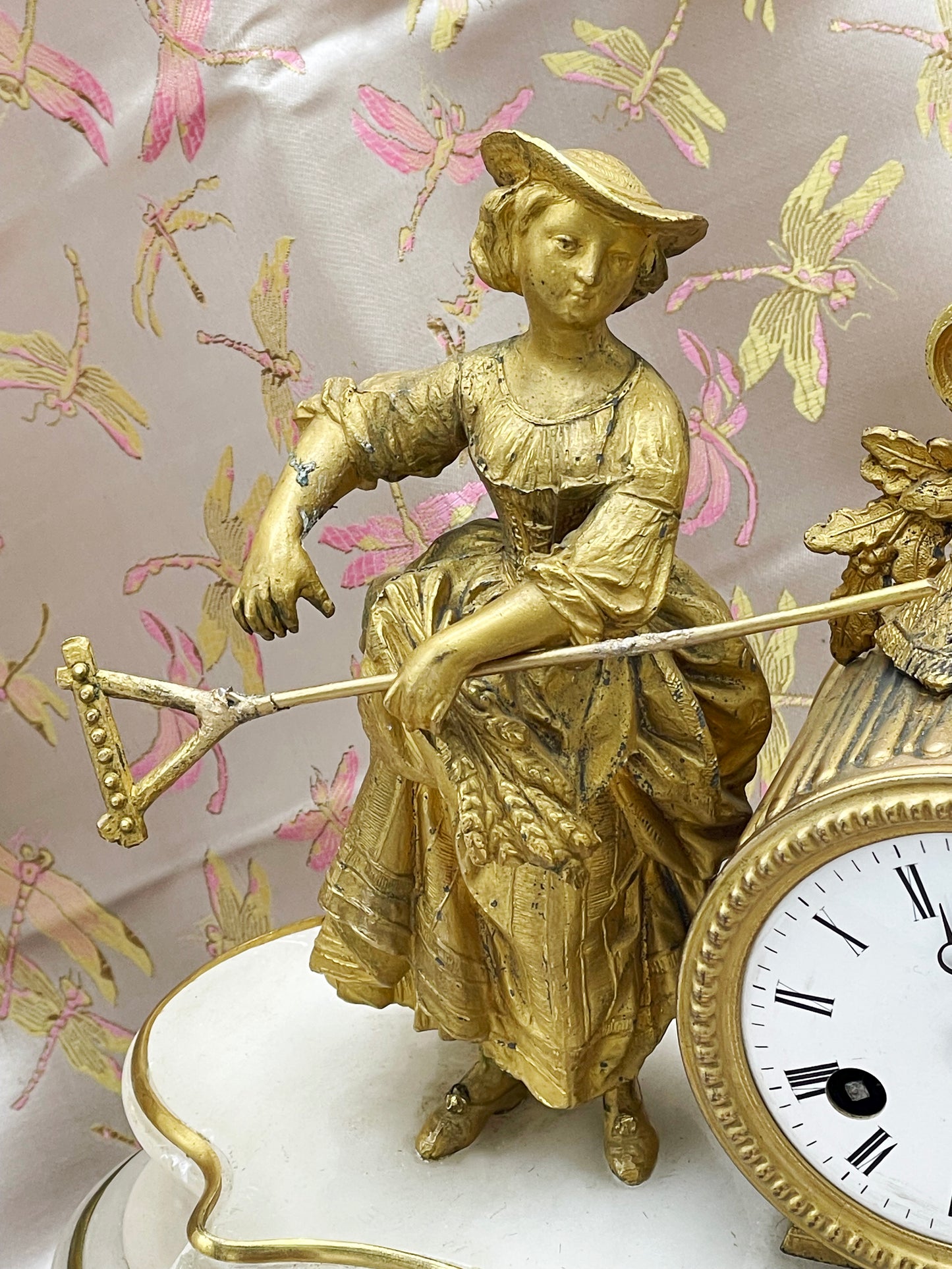 French marble and ormolu mantel clock under glass dome showing the gilt figure and flowering urn
