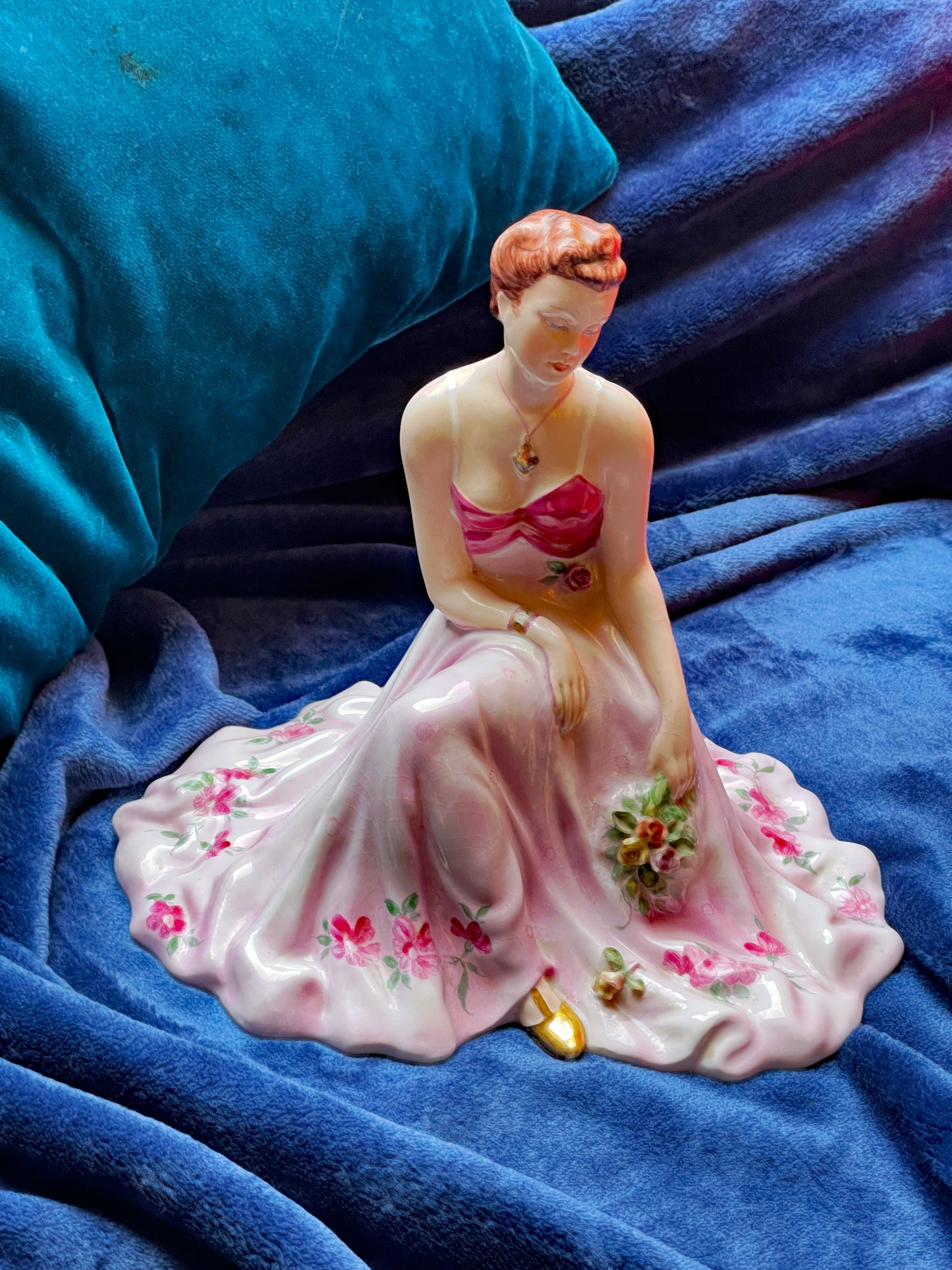 Seated porcelain dancer holding roses, hand-painted