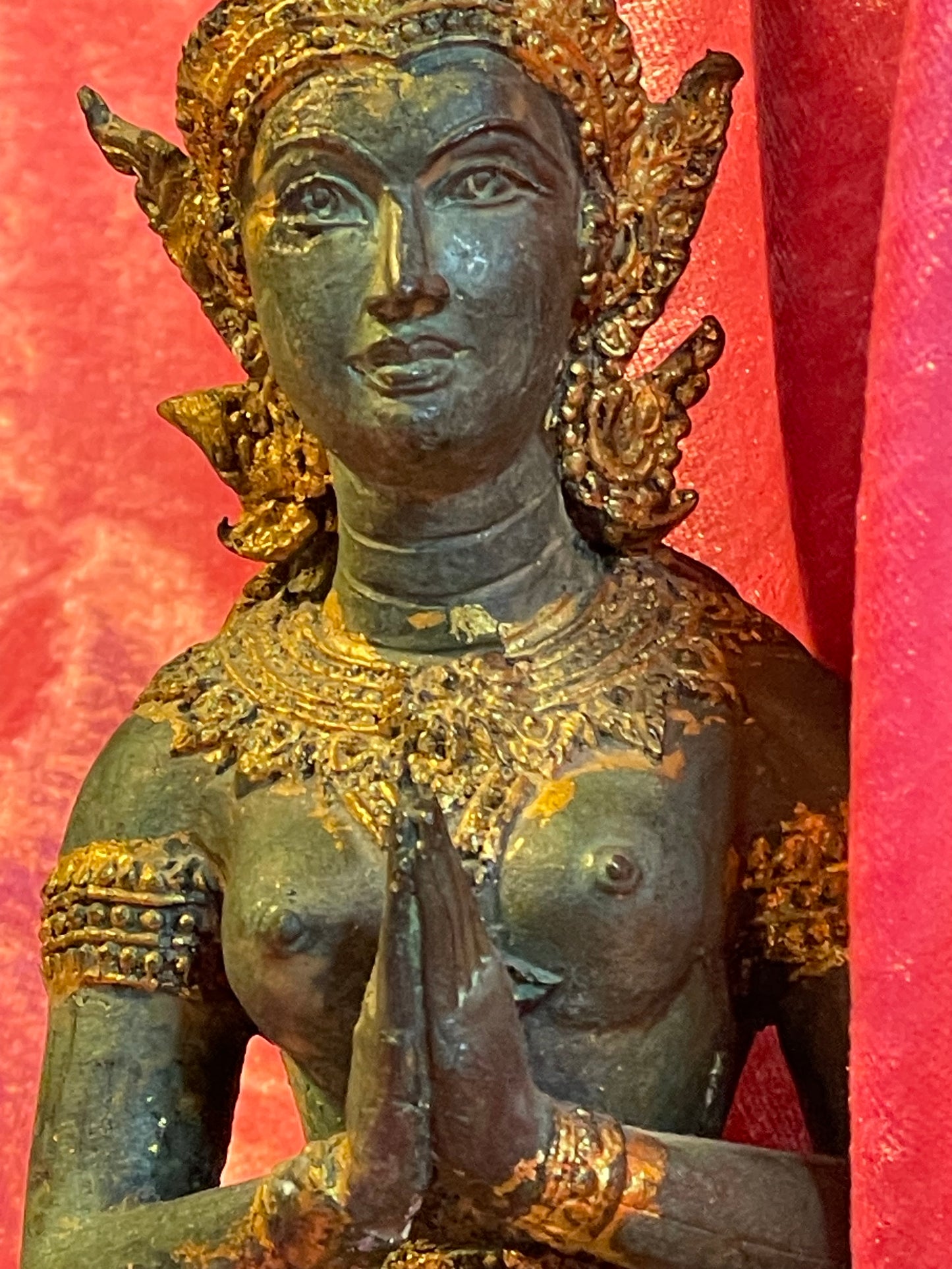 Teppanom guardian face and prayer hands close-up, ornate crown and jewelry