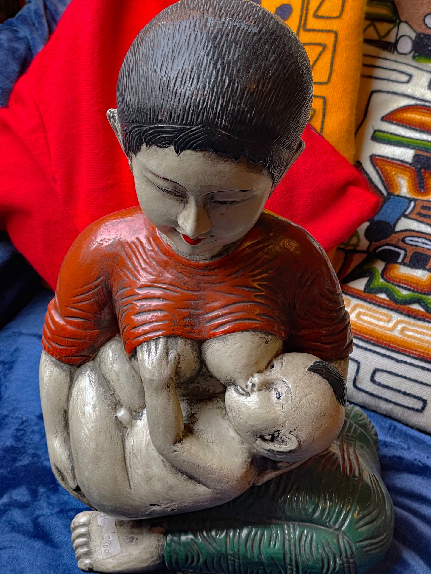 Detail of carved red bodice and seated mother figure