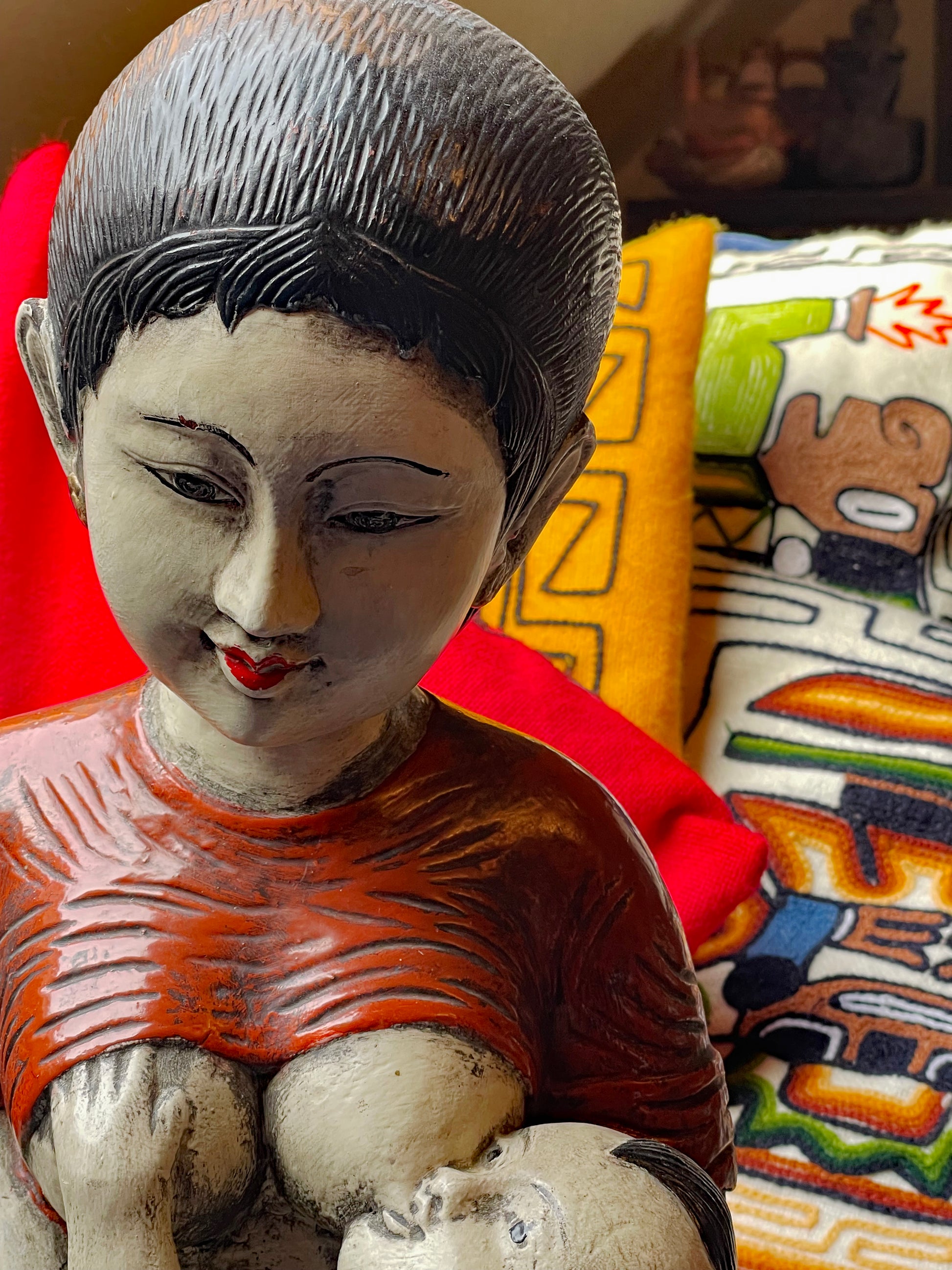 Polychrome painted wood sculpture detail, child nursing