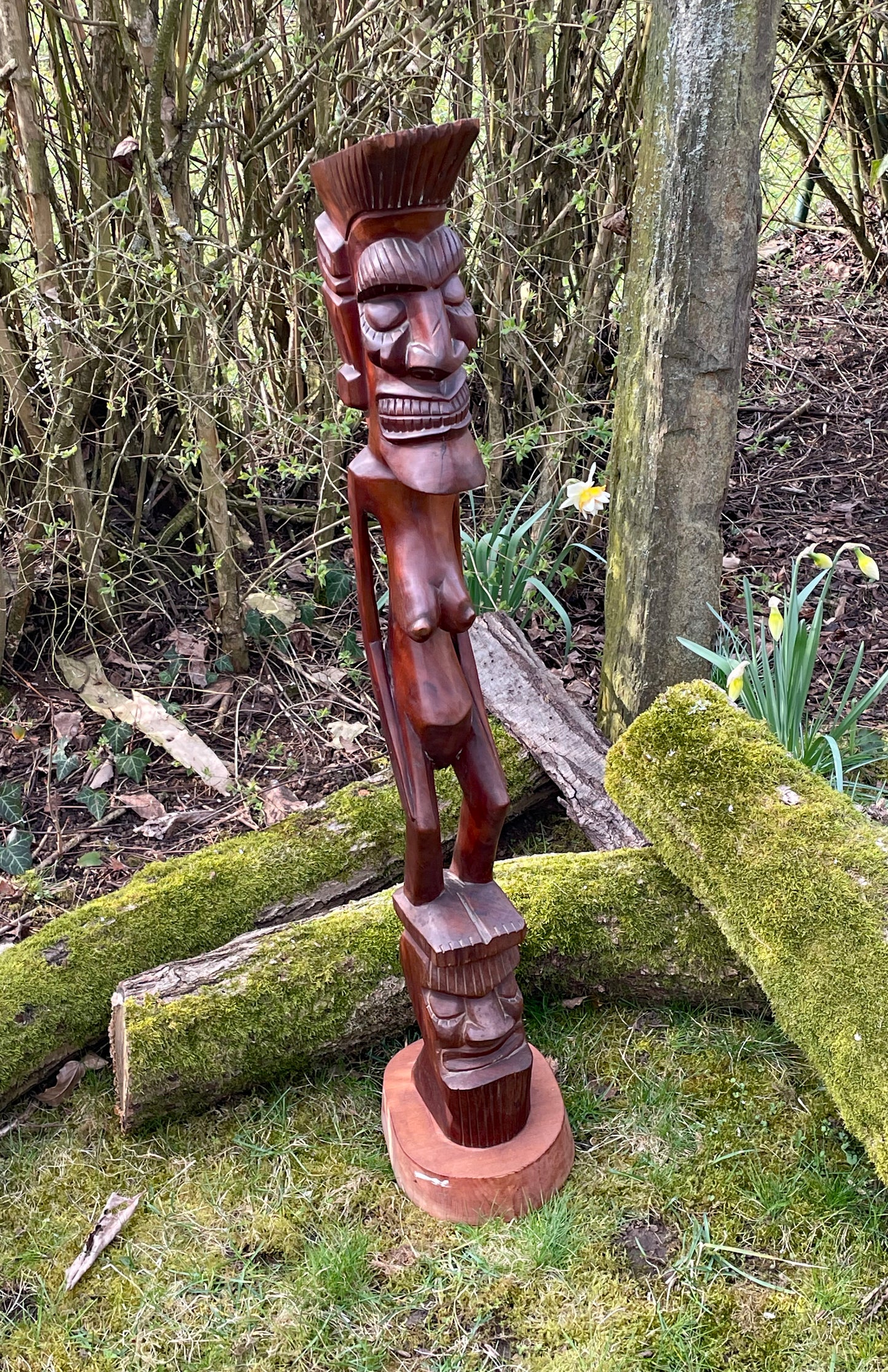 Lobi protective spirit figure full front view in garden setting