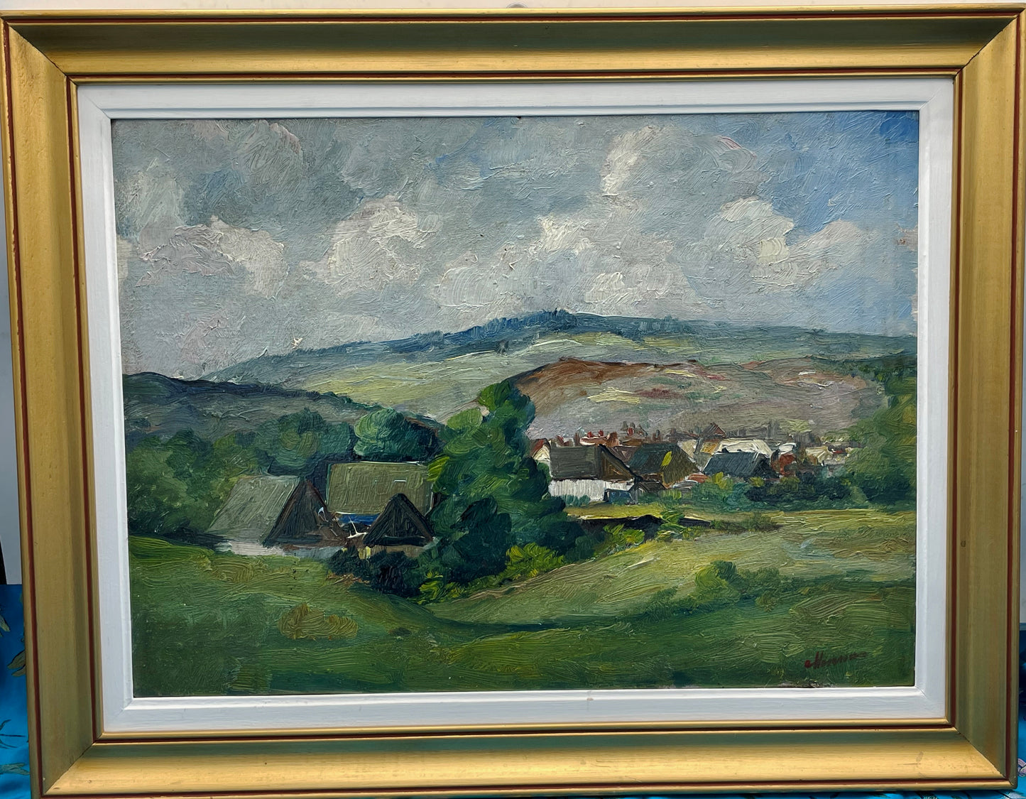Framed Harsia village landscape oil painting, alternate angle showing moulded gold and white frame