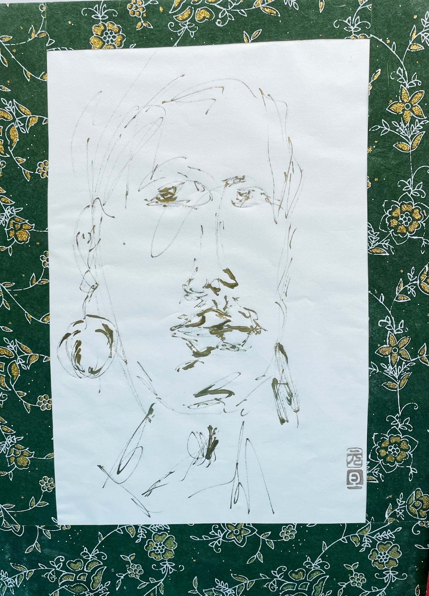 Gold portrait drawing displayed on green and gold floral ground with red seal