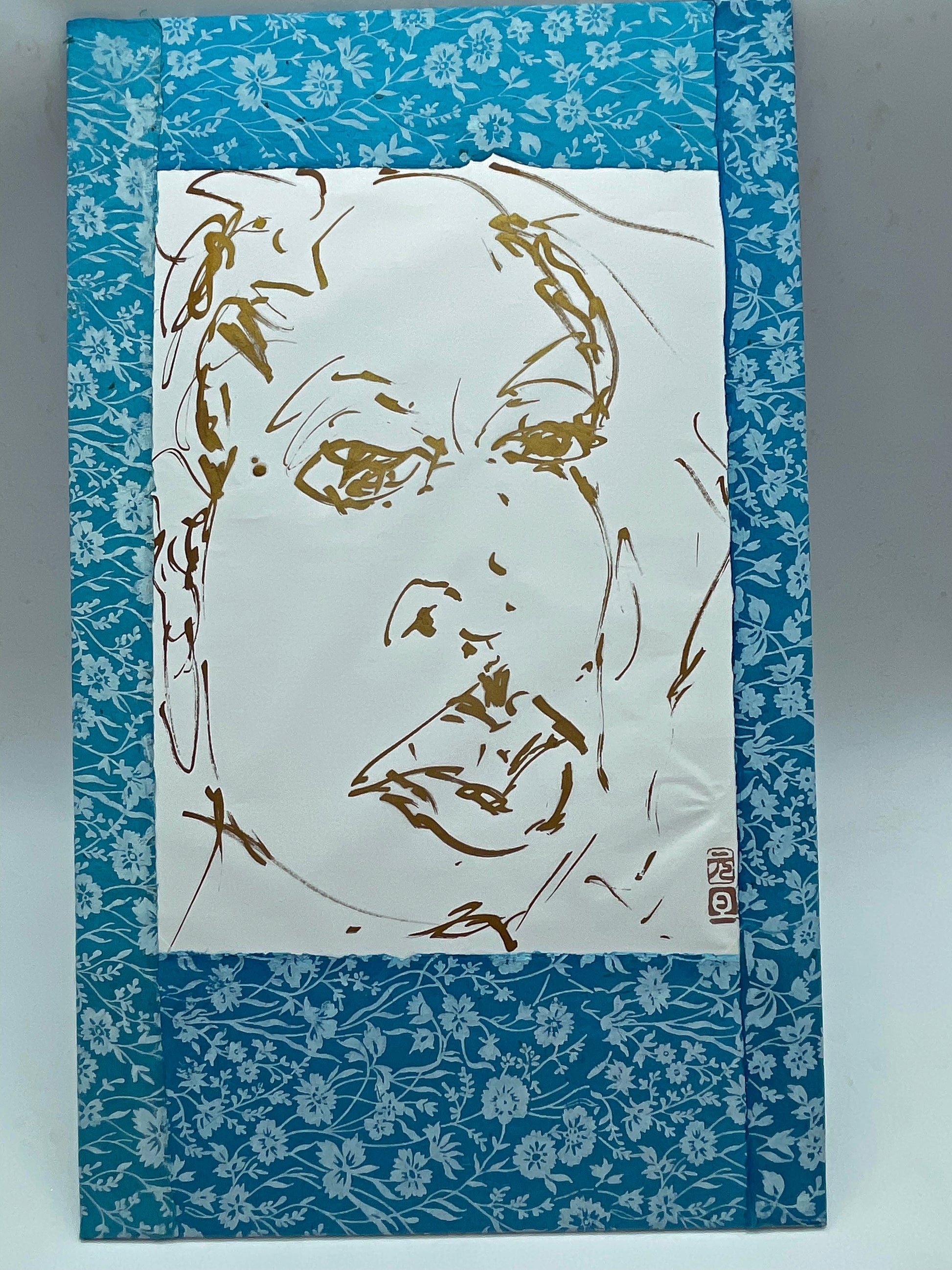 Gestural gold portrait drawing on cream paper, complete sheet
