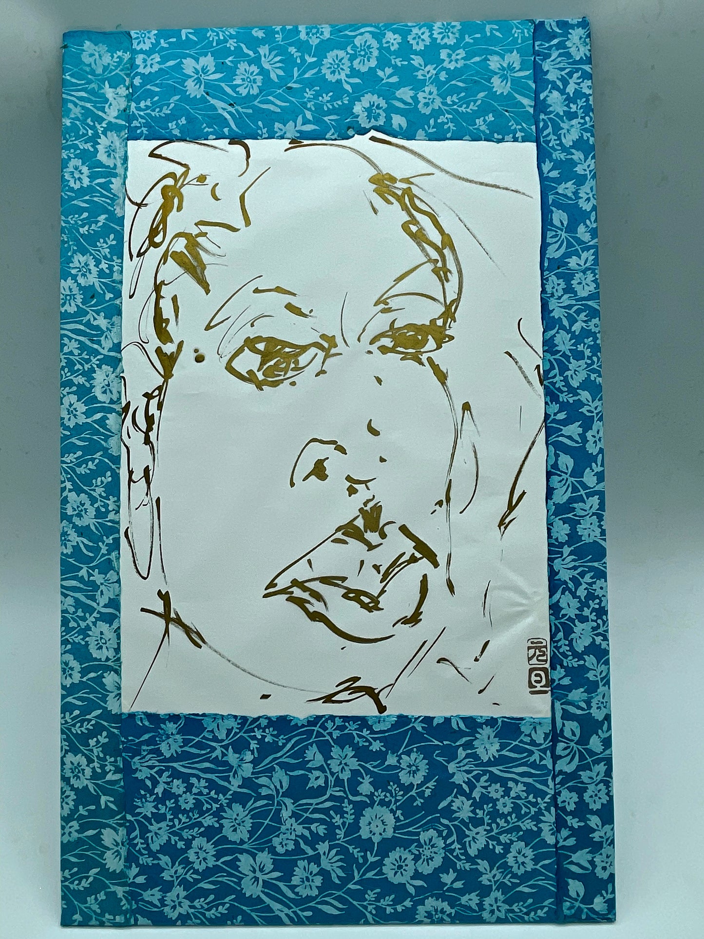 Gold-ink expressive portrait drawing on paper, straight-on full view