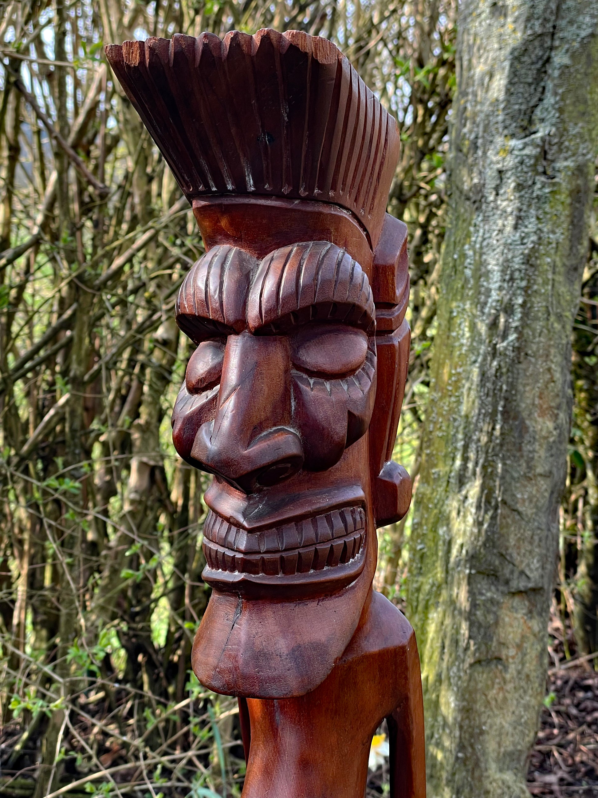 Close-up profile of the carved head with crested coiffure and fierce face