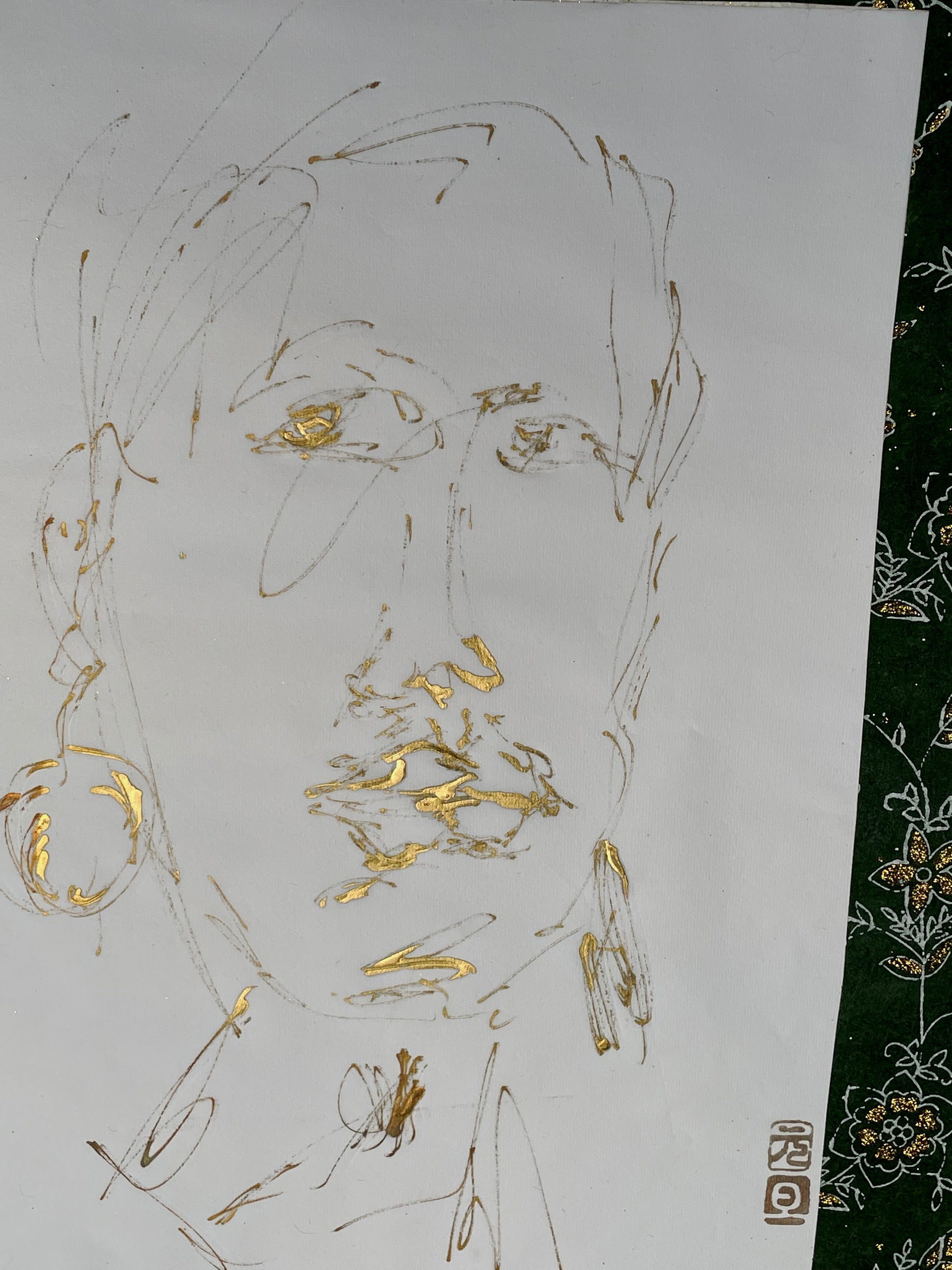 Close detail of gold portrait drawing with red artist's seal in lower corner