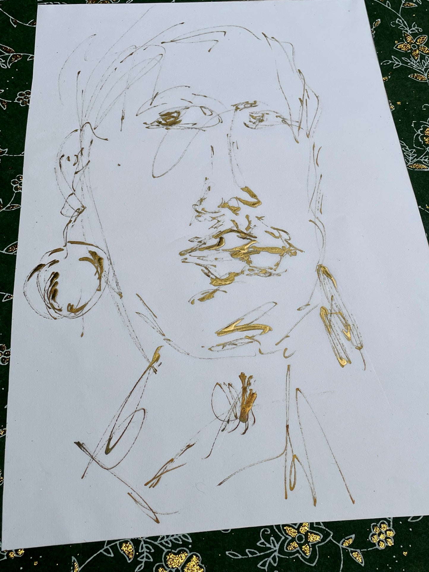 Gold-ink portrait drawing on white paper with bright metallic gold features, full sheet view