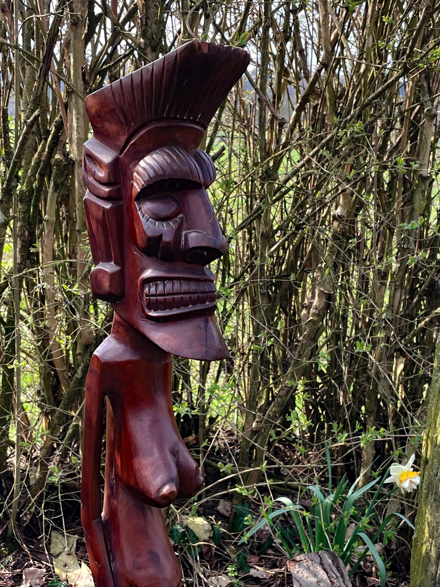 Upper body detail of the carved female figure with patinated hardwood surface