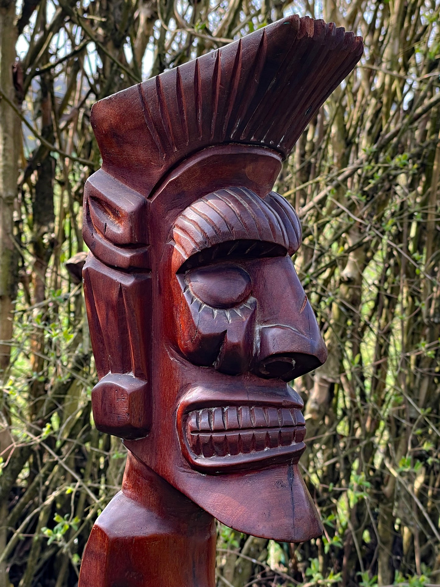 Detailed close-up of the spirit figure's face showing grain eyes and patina