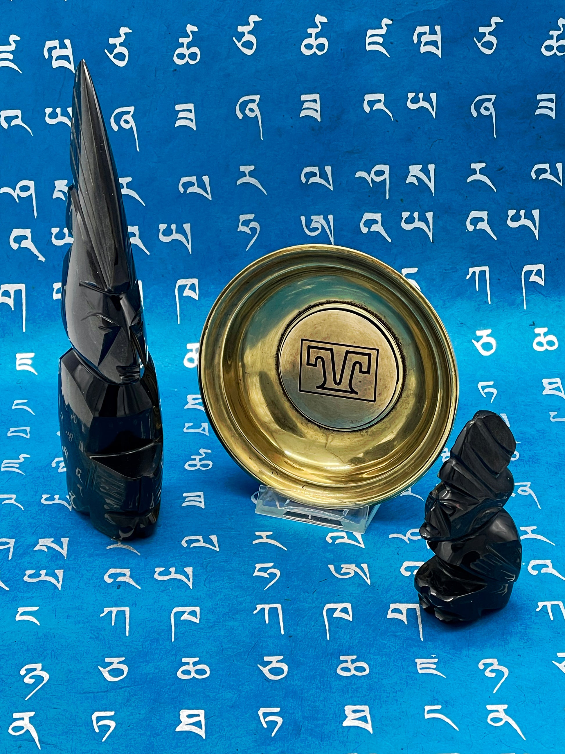 Larger black stone figure with feathered crest