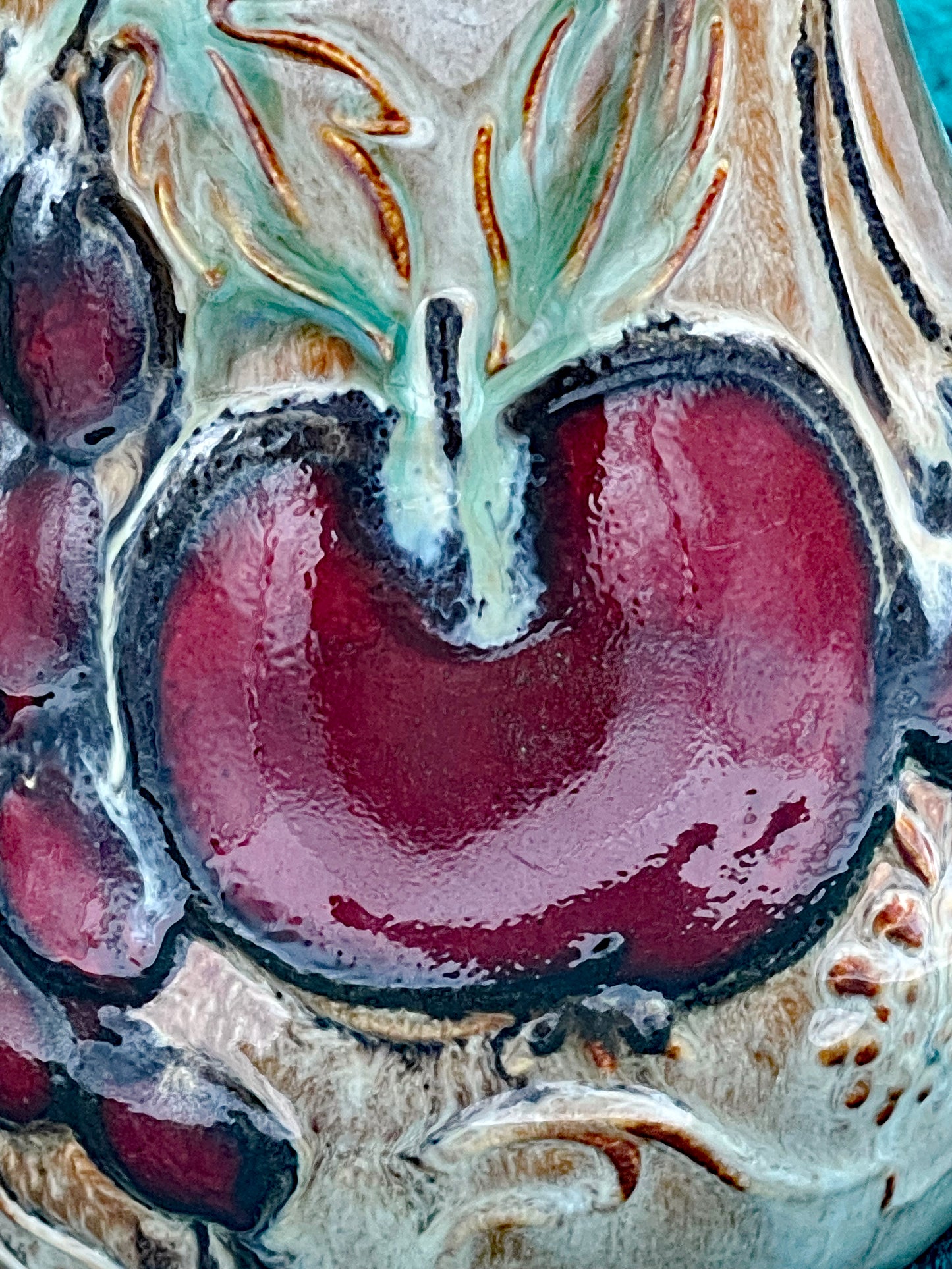 Close-up of the glossy red apple relief with green leaf accents