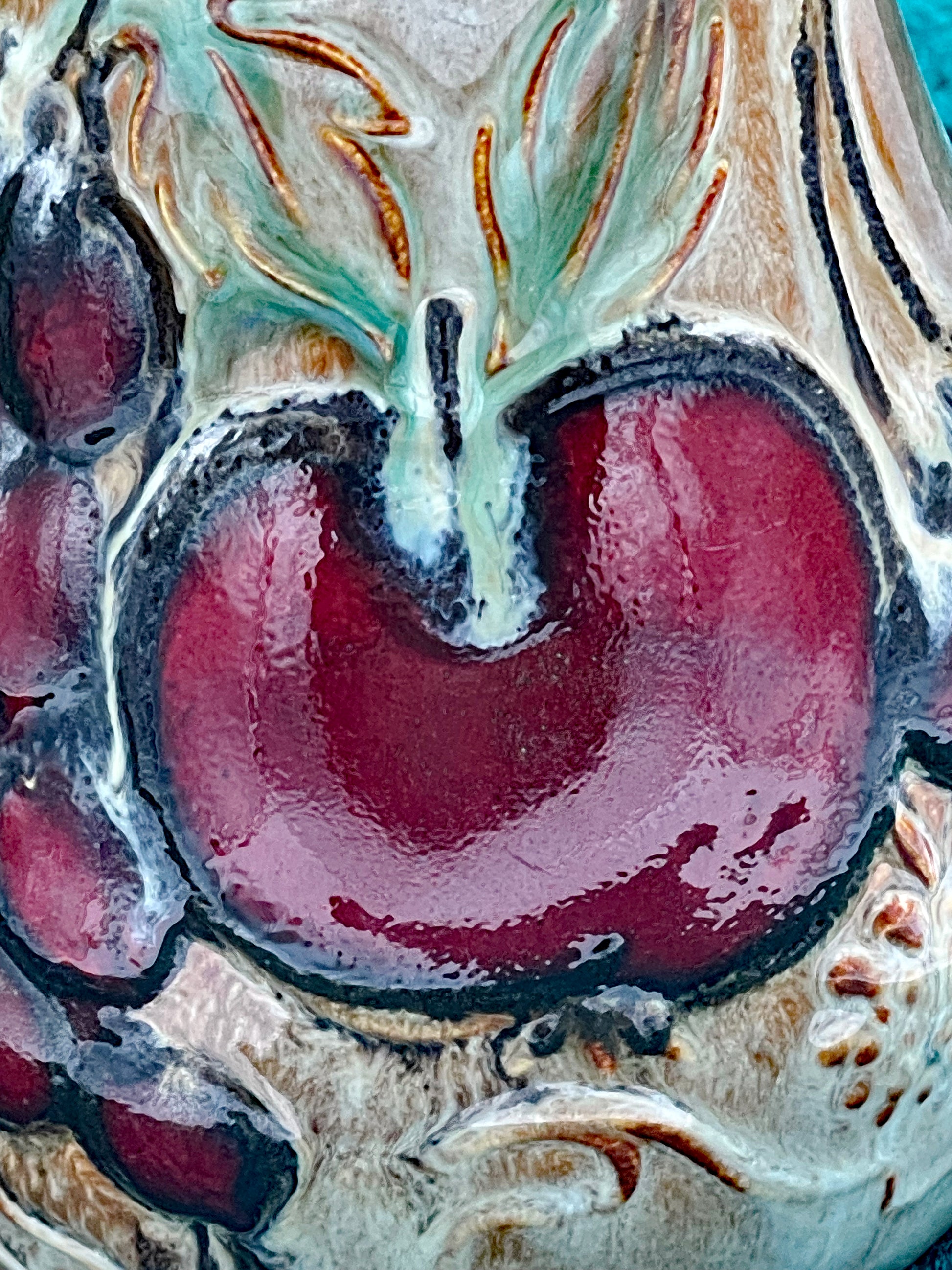 Close-up of the glossy red apple relief with green leaf accents