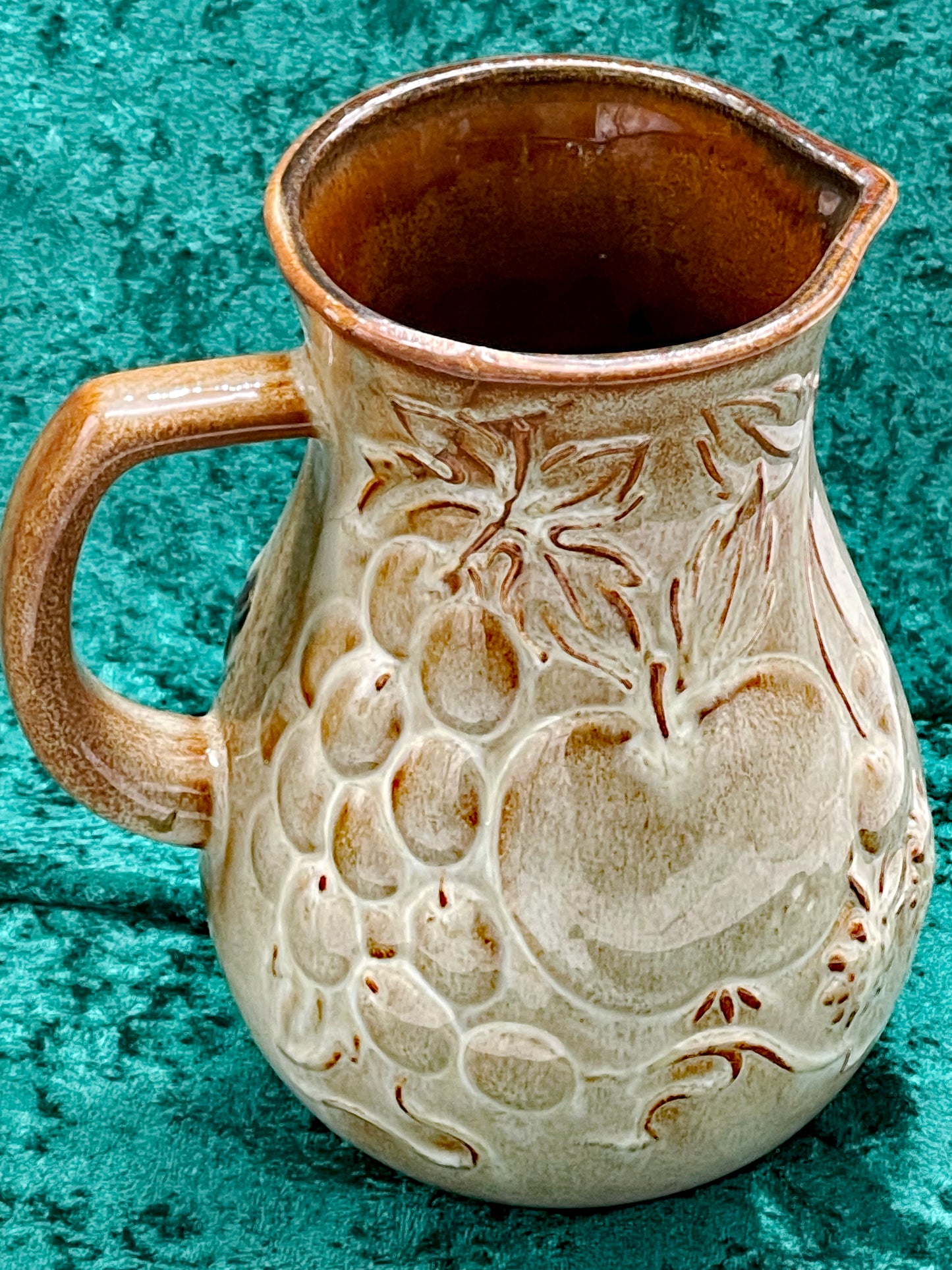 Reverse side of the jug, the same fruit relief left in bare cream glaze