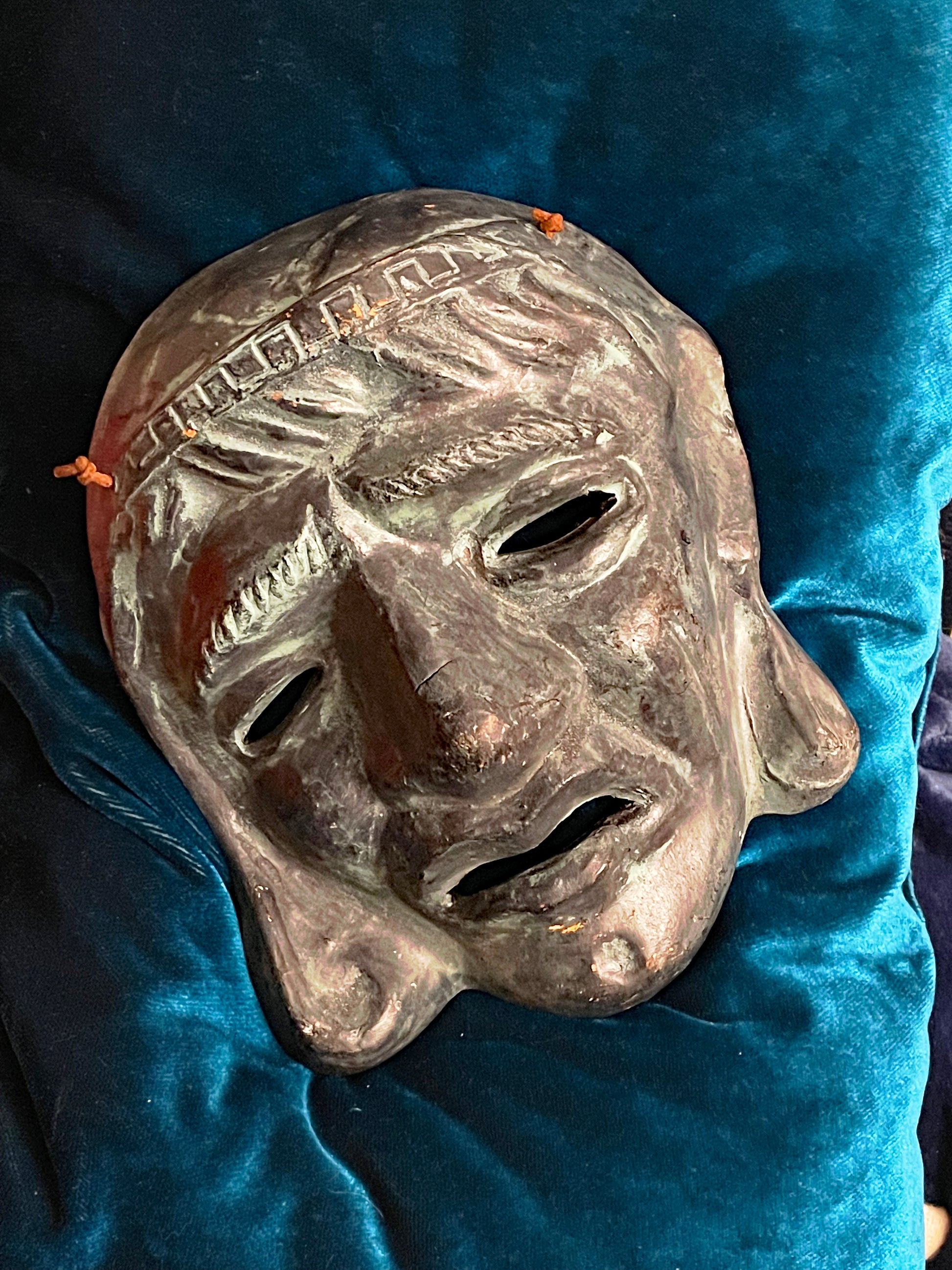 Greek tragedy theatre mask in glazed terracotta with green patina, front view