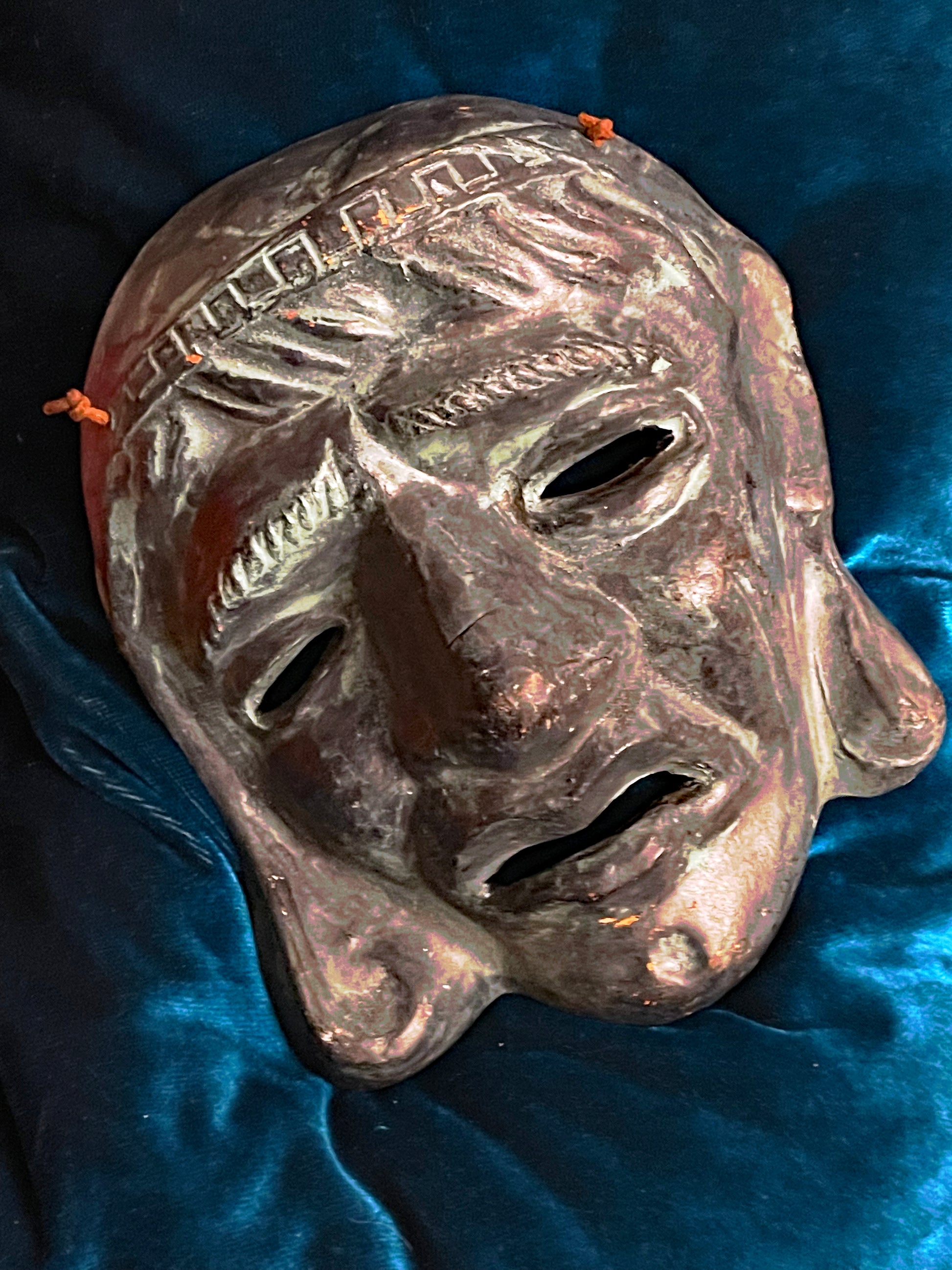Greek terracotta theatre mask detail showing relief modelling and patina