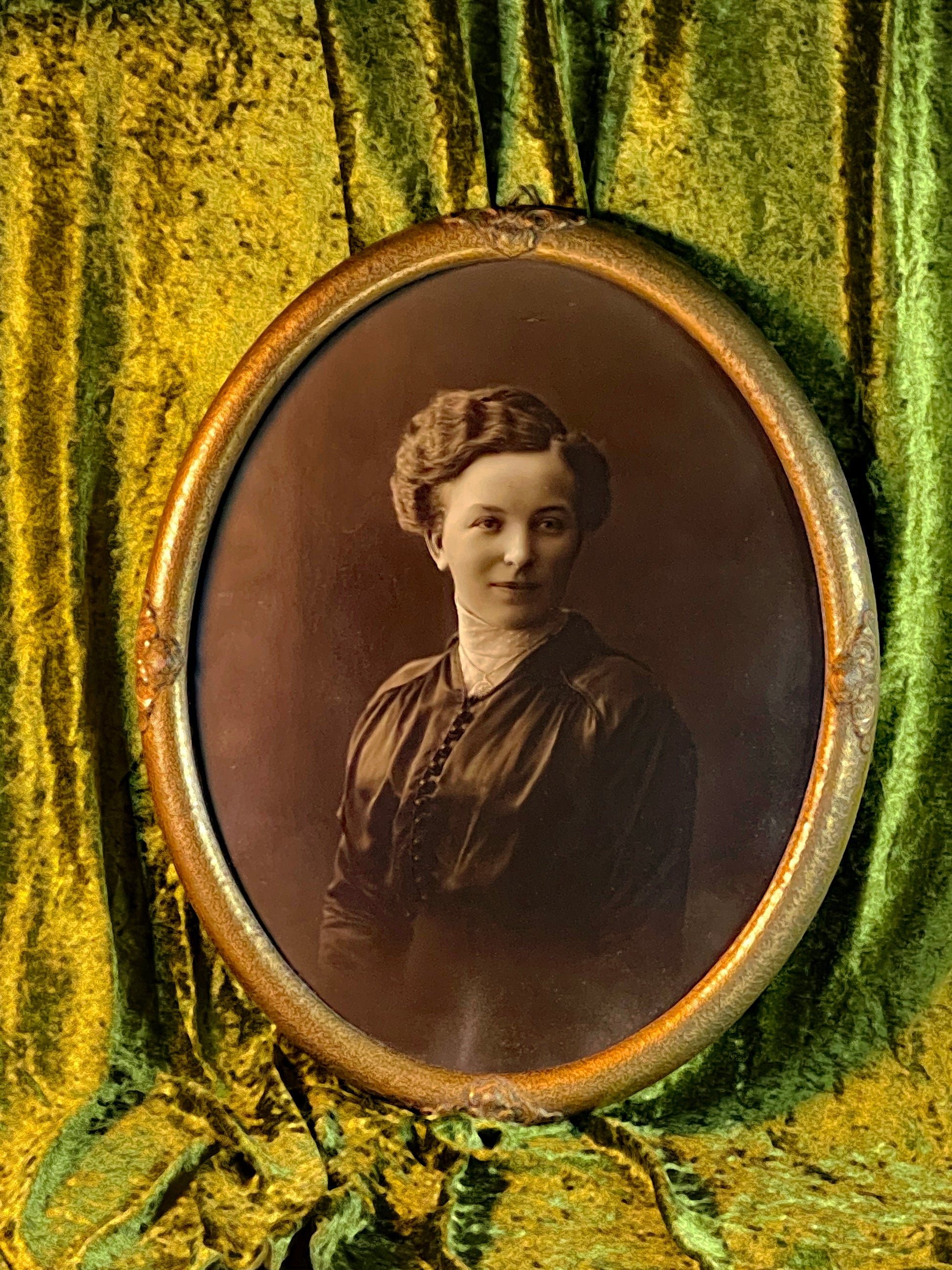 Vintage sepia portrait of a young woman in original gilded oval frame