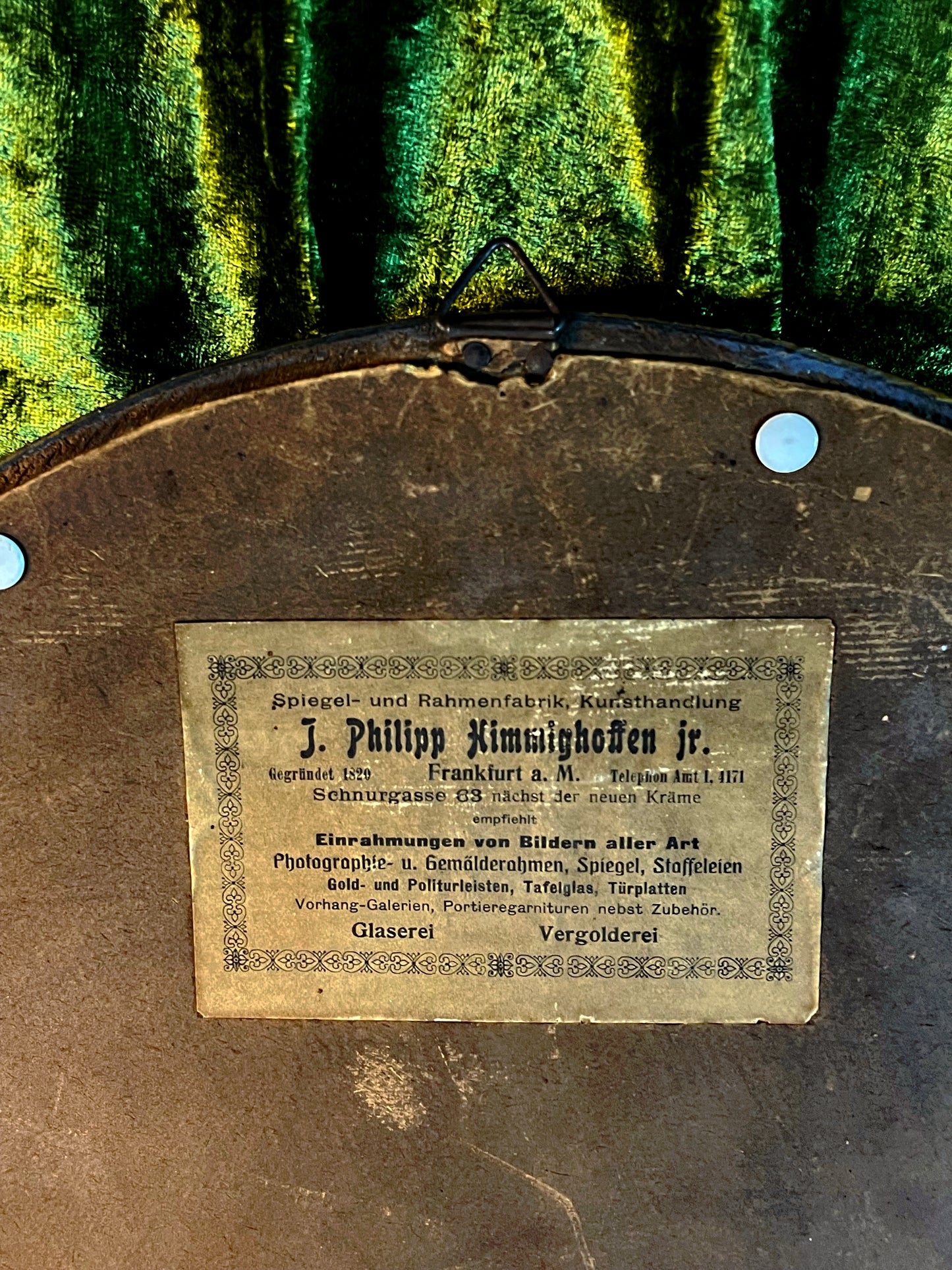 Full view of the vintage oval portrait against draped fabric