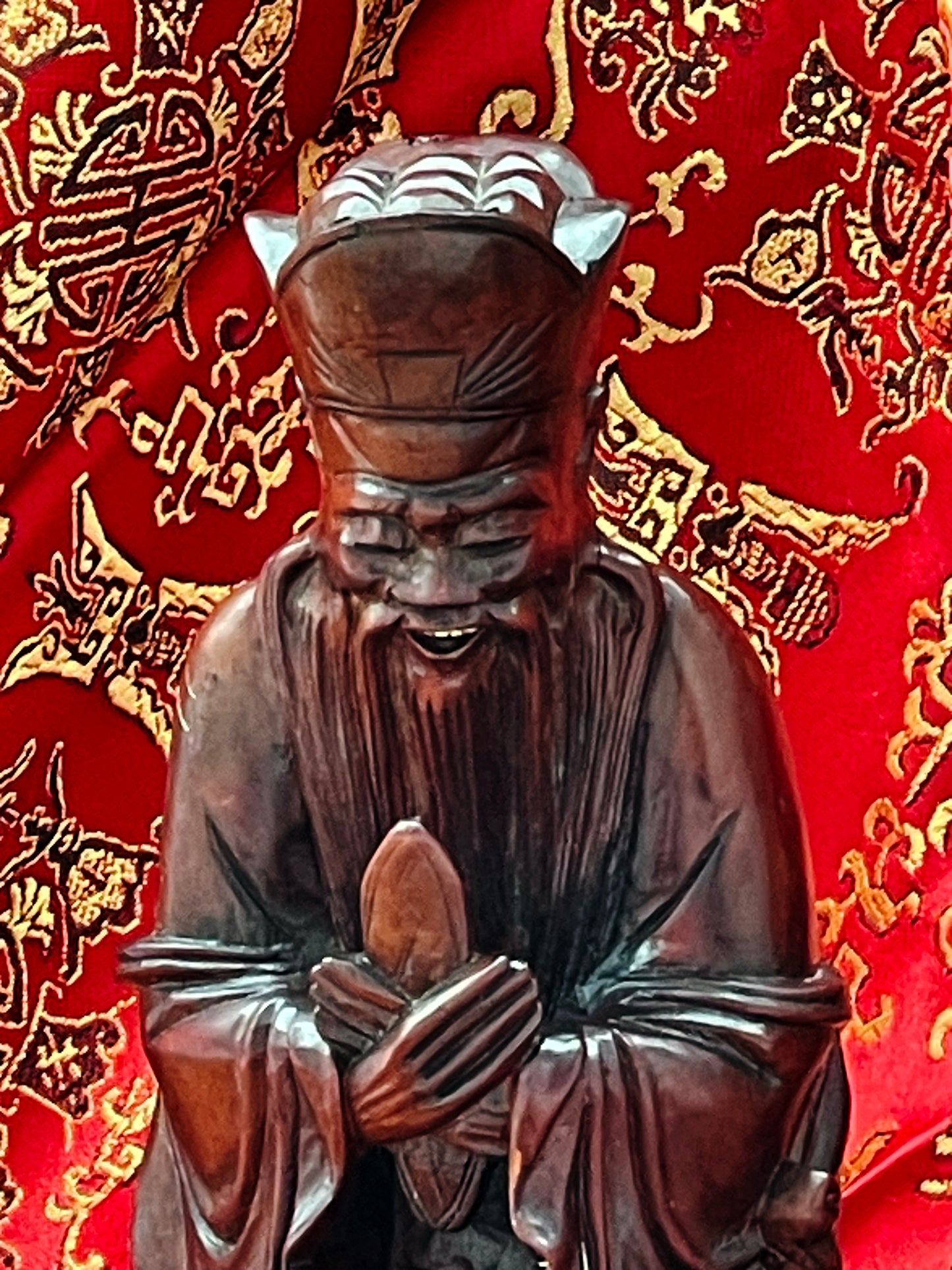 Confucius figure holding scroll, close detail