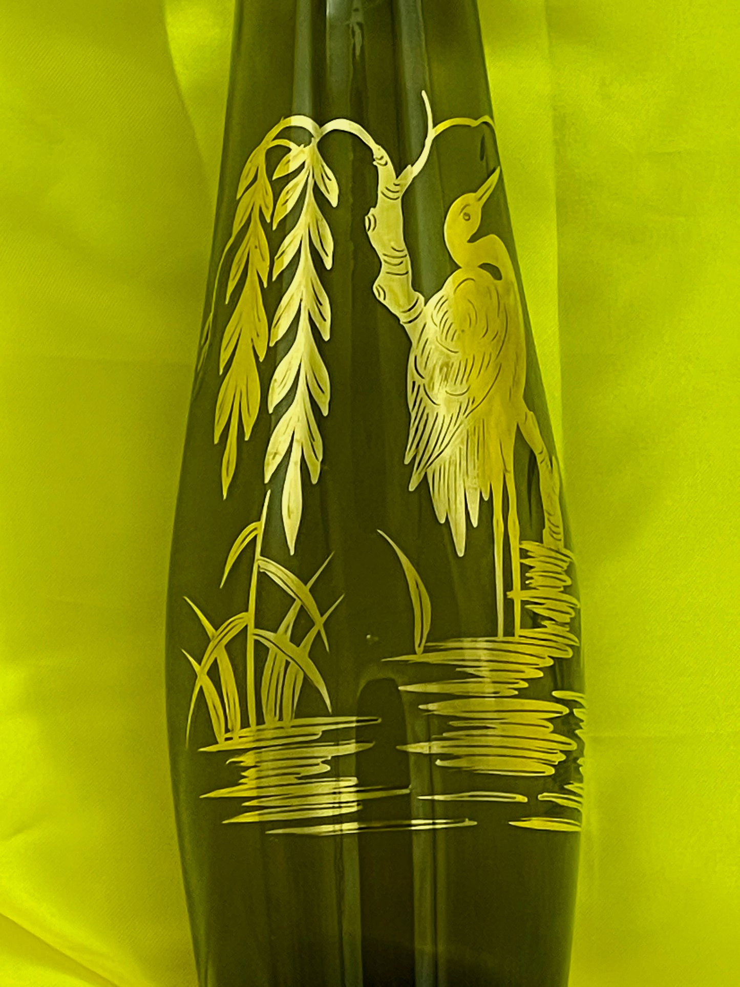 Gilded reed and water detail on the green glass vase