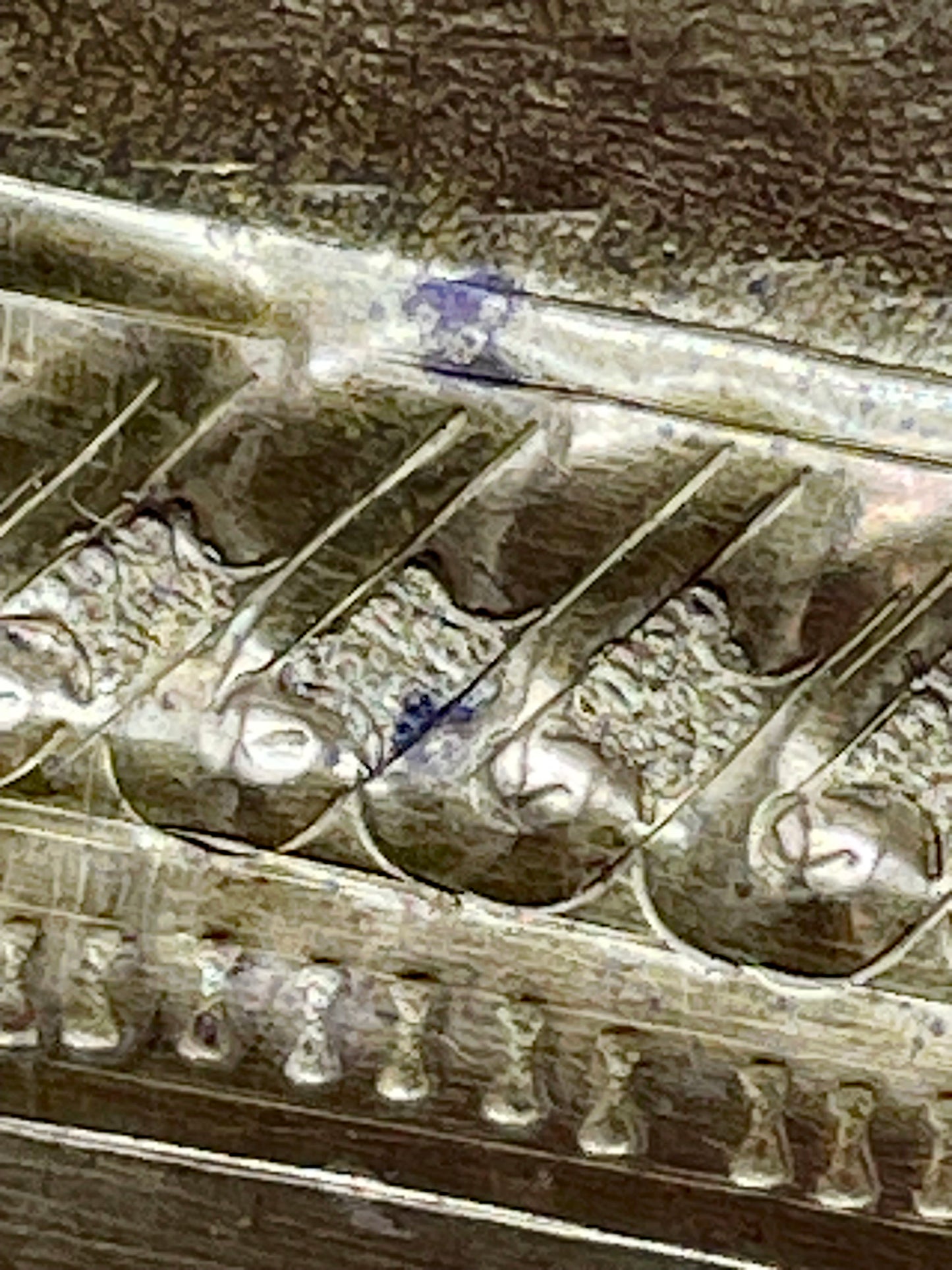 Repoussé border detail showing the hand-raised brasswork