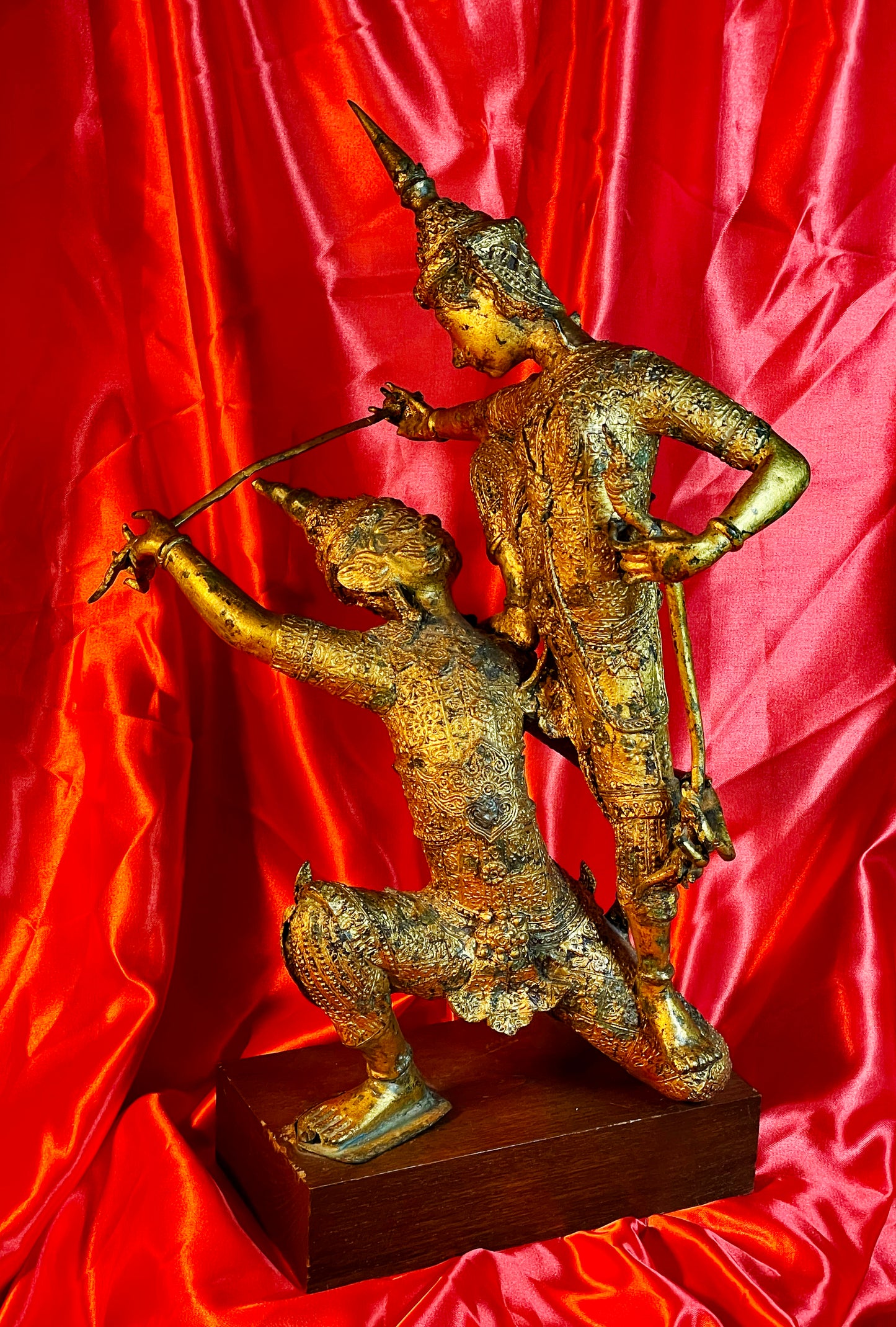 Antique Thai gilt bronze statue of two fighting temple guardians, front view on hardwood base