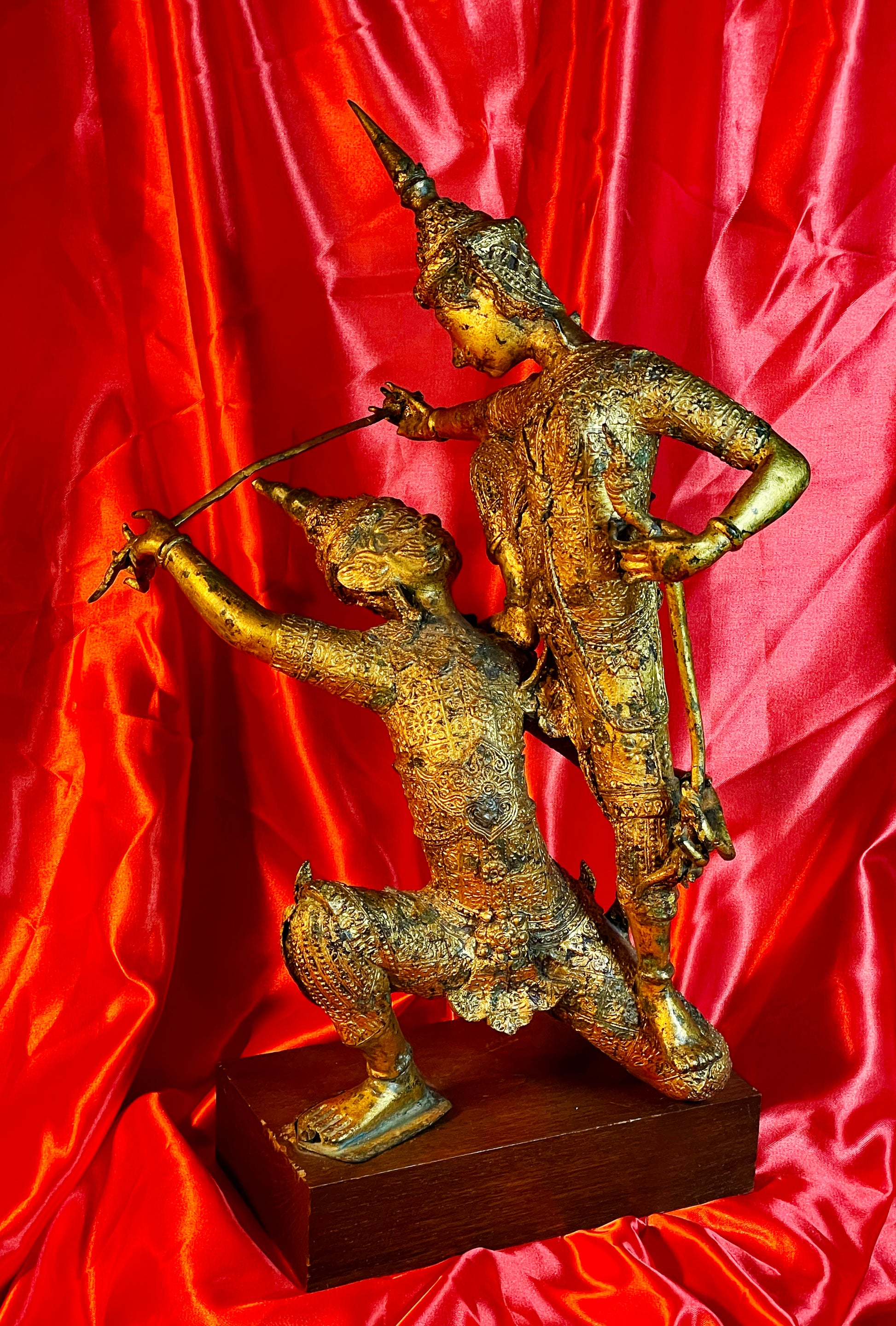 Antique Thai gilt bronze statue of two fighting temple guardians, front view on hardwood base