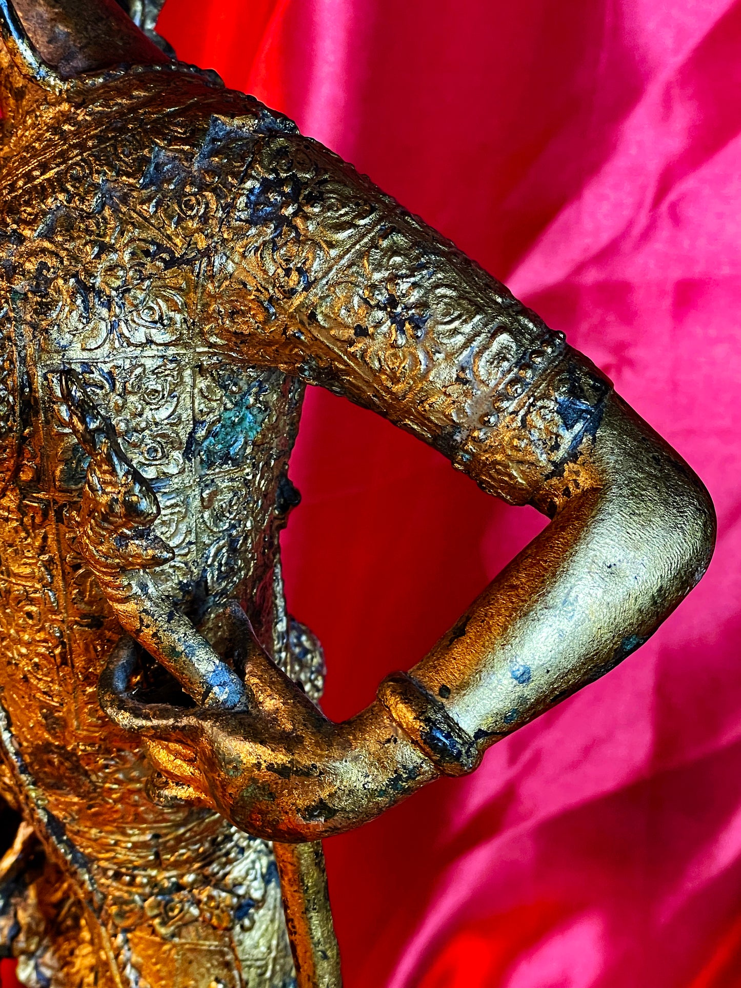 Detail of fire gilded chased robe and arm of the temple guardian
