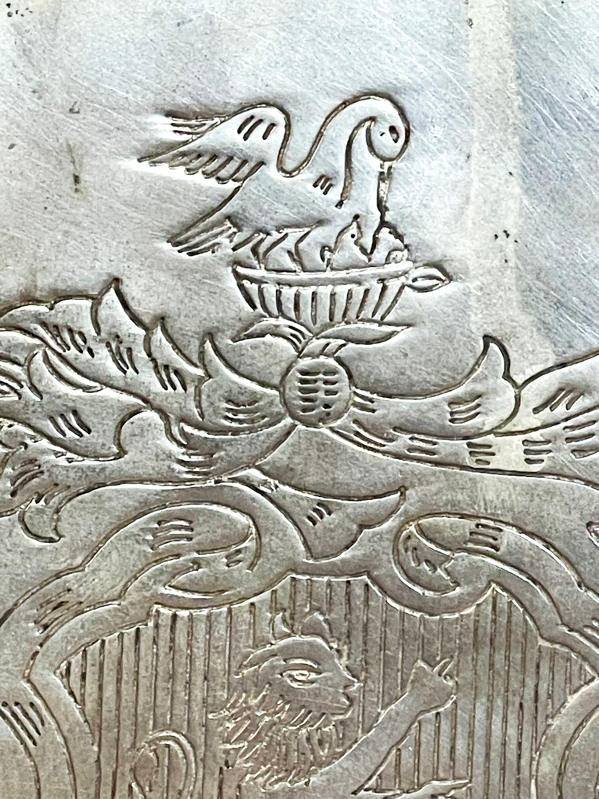 Detail of the engraved pelican crest above the armorial on the silver cooler