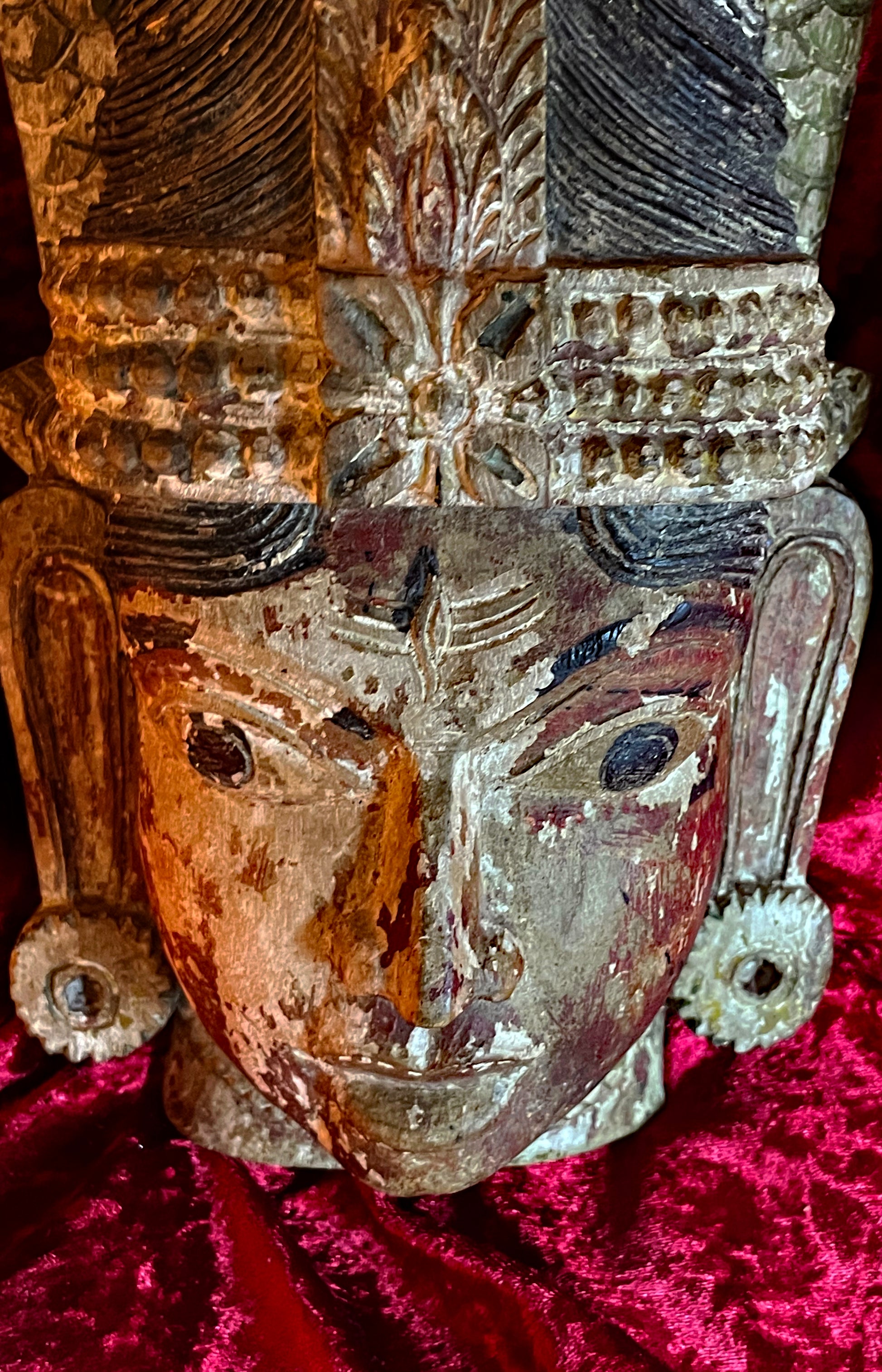 Close-up of the polychrome carved face of the South Indian Naga deity