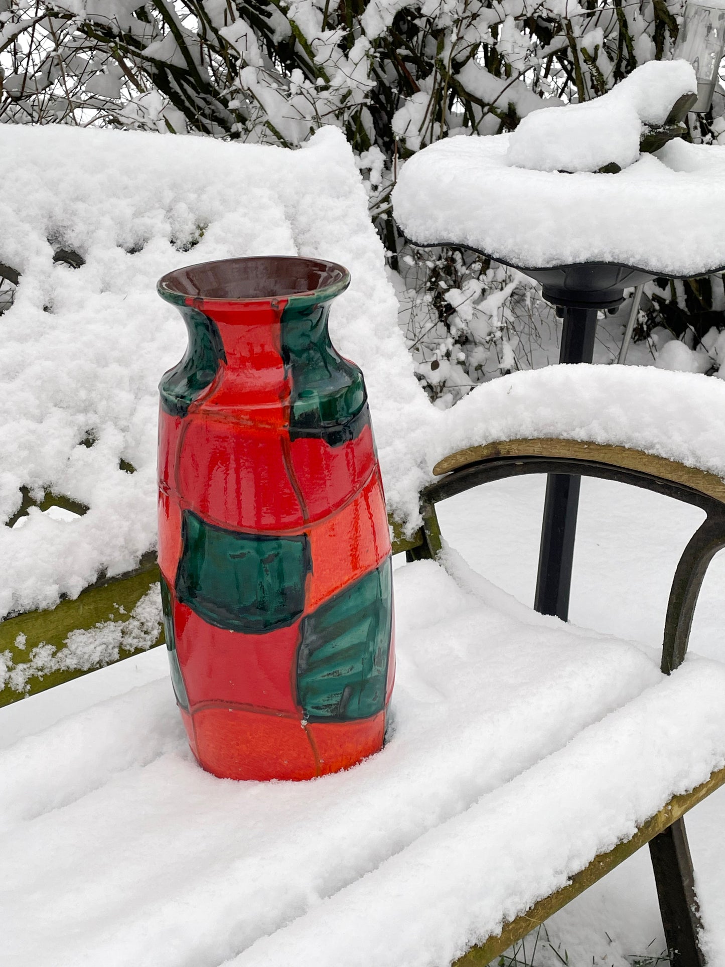 Red and green West German Scheurich vase standing on a garden bench